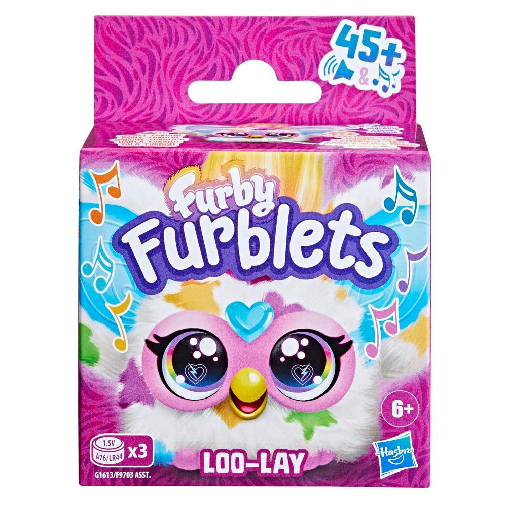 Caja de Furby Furblets. Colores rosa, blanco y azul. Presenta una cara de Furby, notas musicales y el logotipo de Hasbro. Incluye clasificaciones por edad.