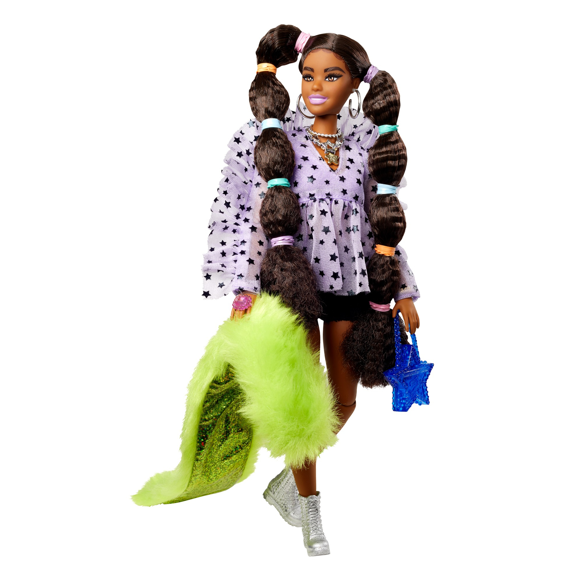 Eine Modepuppe mit langen geflochtenen Haaren, die ein Top mit Sternenmuster, Shorts und silberne Stiefel trägt und eine grüne Boa und eine Sternenhandtasche hält.