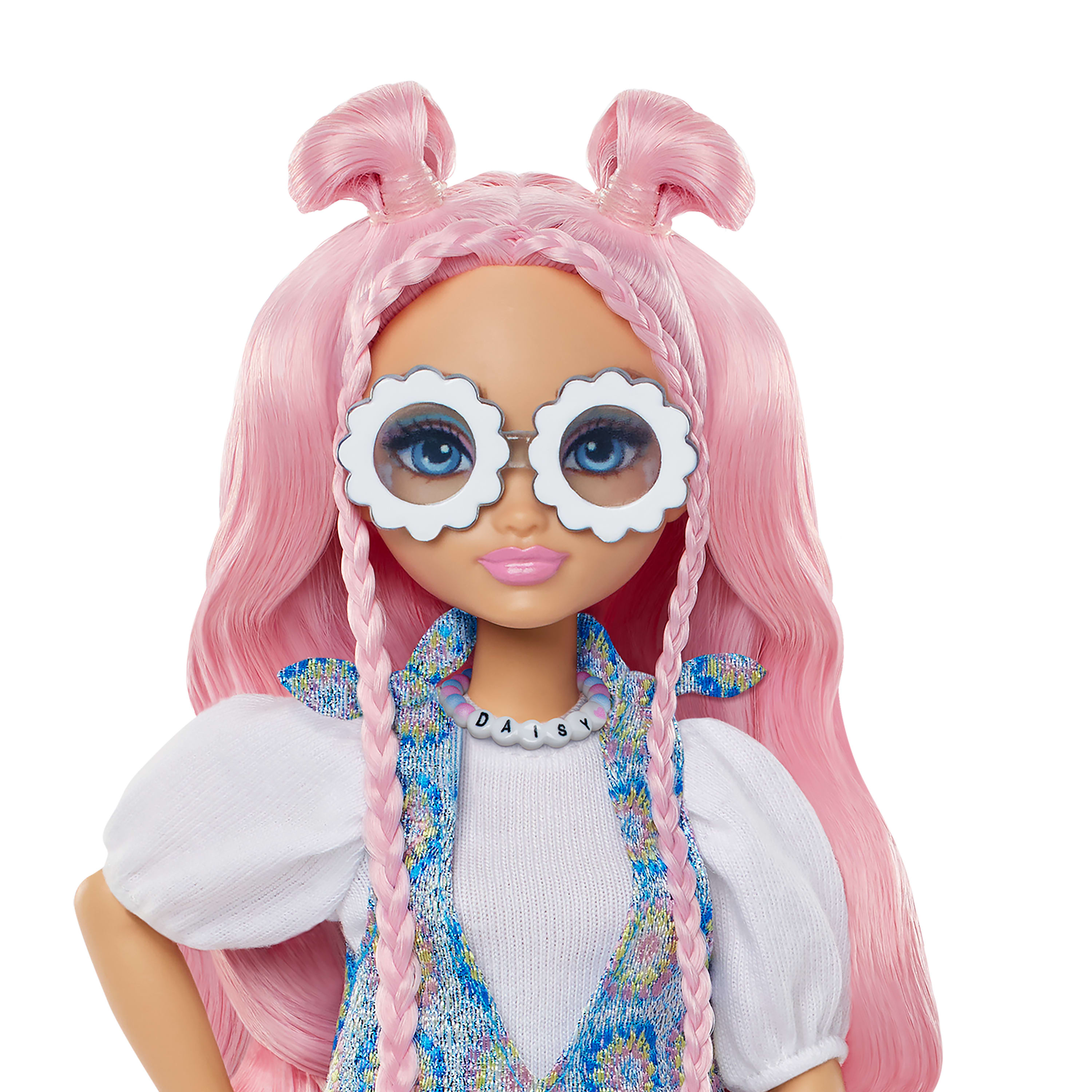 Una muñeca con cabello rosado, gafas en forma de margarita y un collar que dice DAISY. Viste una blusa blanca y un chaleco azul.