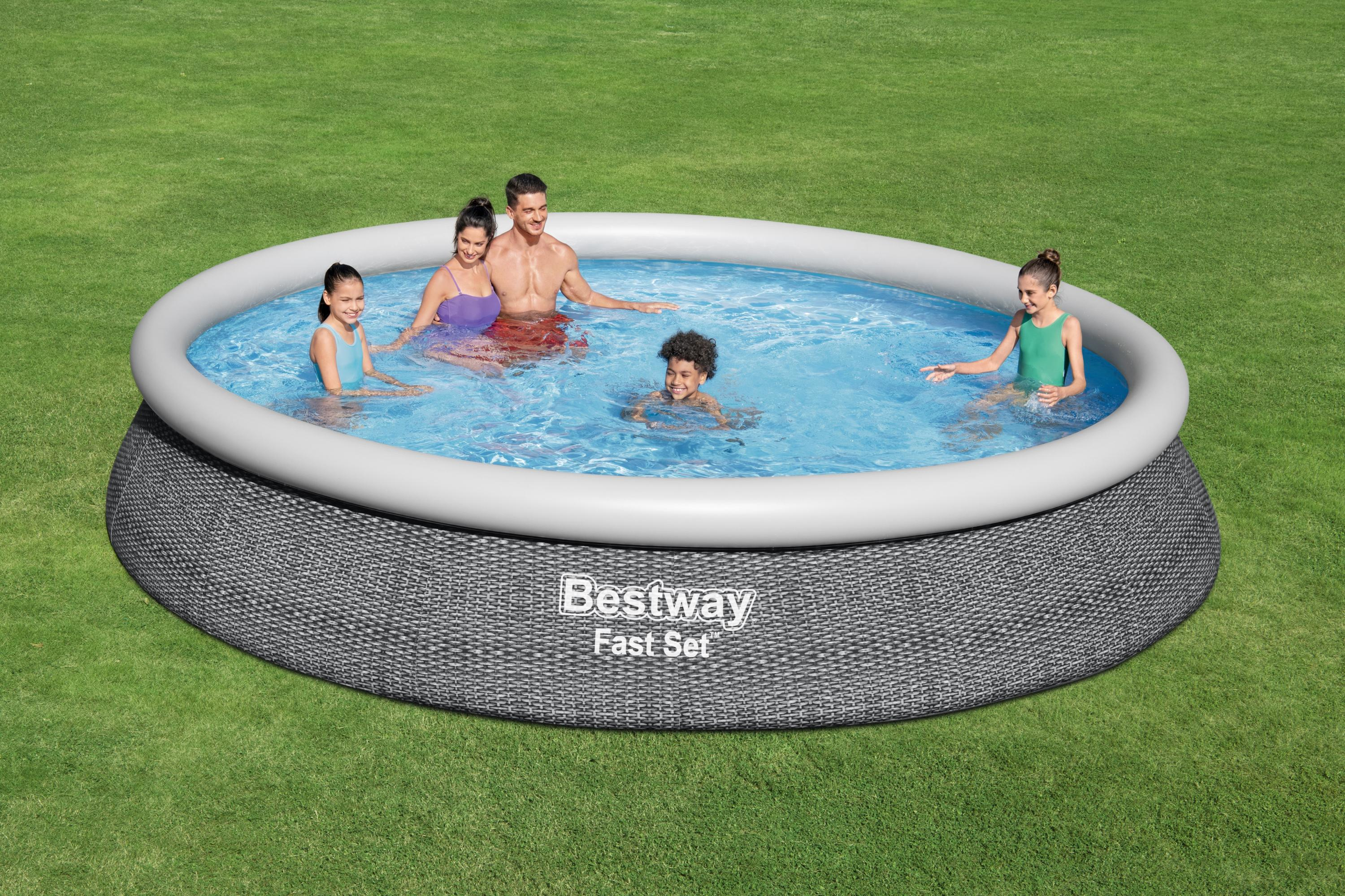 Familie in einem Pool auf Gras. Personen sind im Wasser, ein Bestway-Pool. Grüner Gras-Hintergrund.