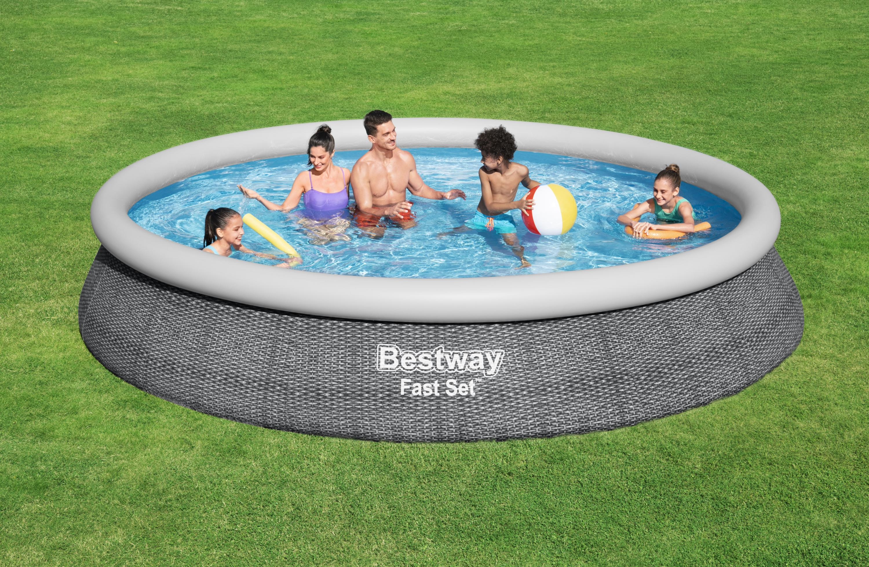 Familie in einem Pool auf einer Wiese. Leute schwimmen und spielen mit einem Beachball und einer Schwimmnudel.