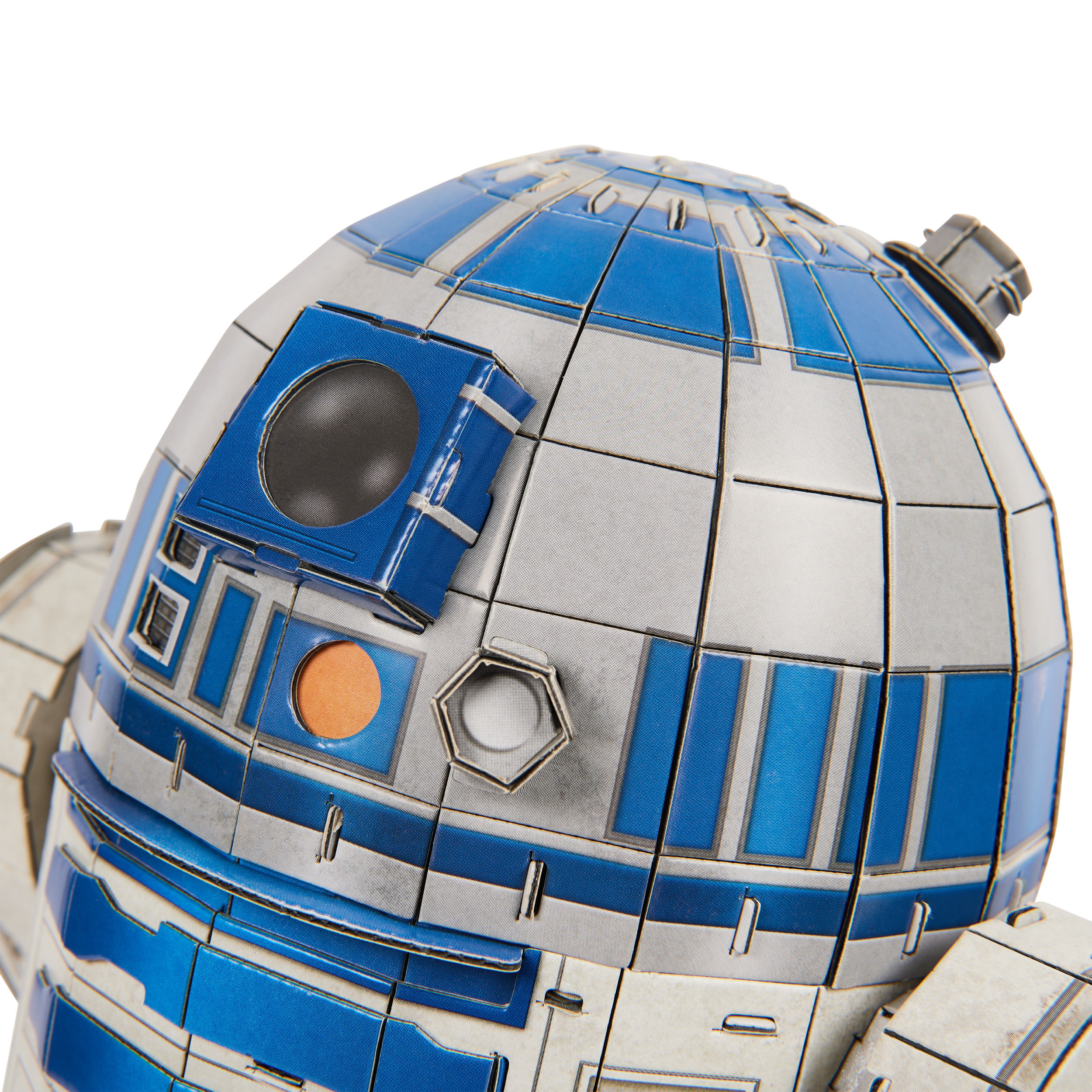 Zbliżenie modelu R2-D2. Droid jest niebieski, biały i srebrny. Cechy obejmują czarne oko i pomarańczowy okrąg.
