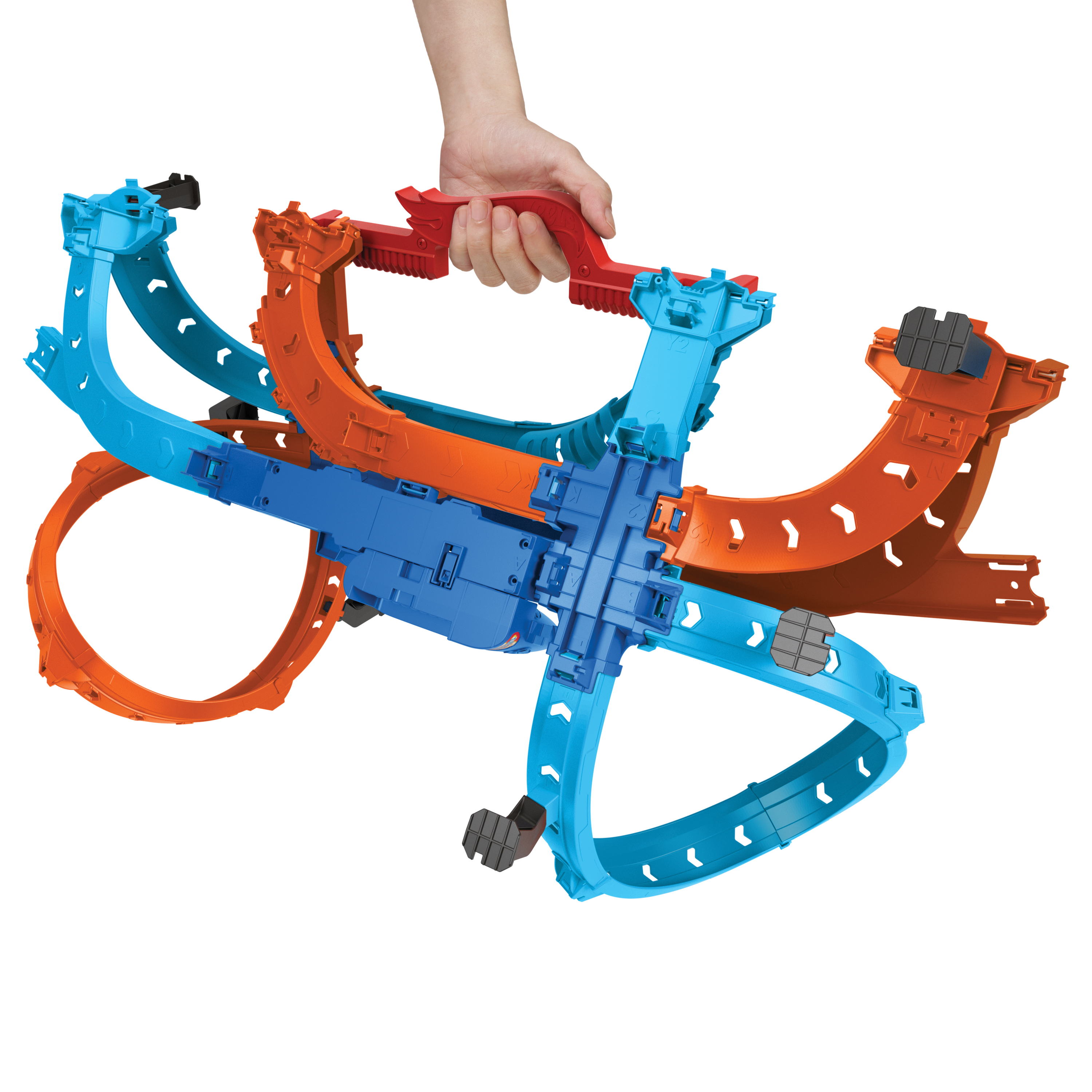 Eine Hand hält einen roten Griff, der an blaue und orangefarbene Spielzeug-Rennstrecken befestigt ist. Weißer Hintergrund.