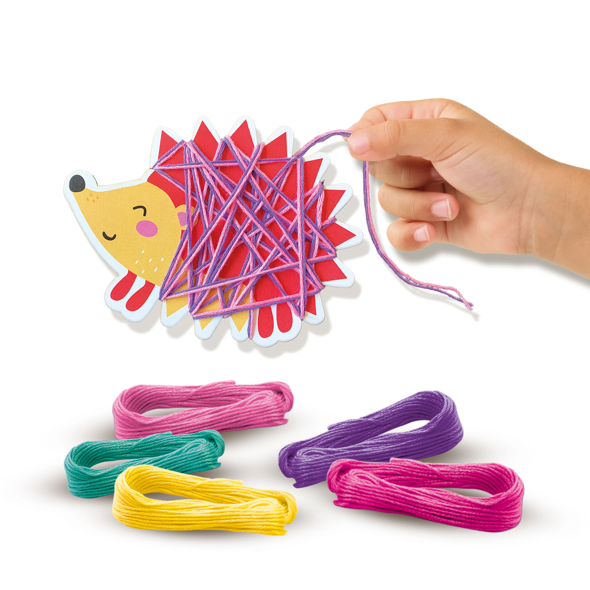 Dłoń trzyma nić przymocowaną do rzemiosła jeża. Poniżej znajdują się kolorowe motki przędzy.