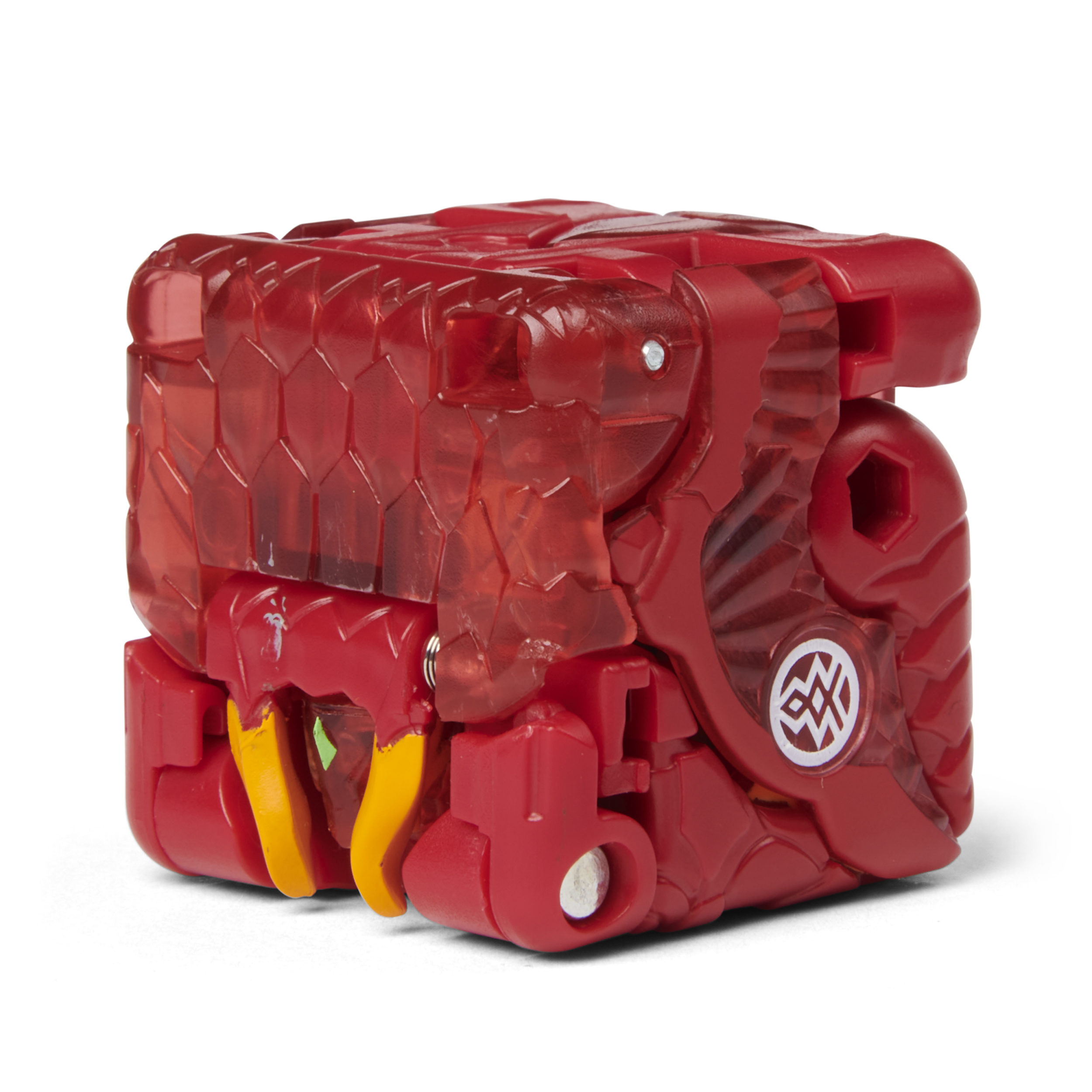Czerwona zabawka w kształcie kostki z przezroczystymi sekcjami. Ma żółte i zielone detale oraz biały symbol.