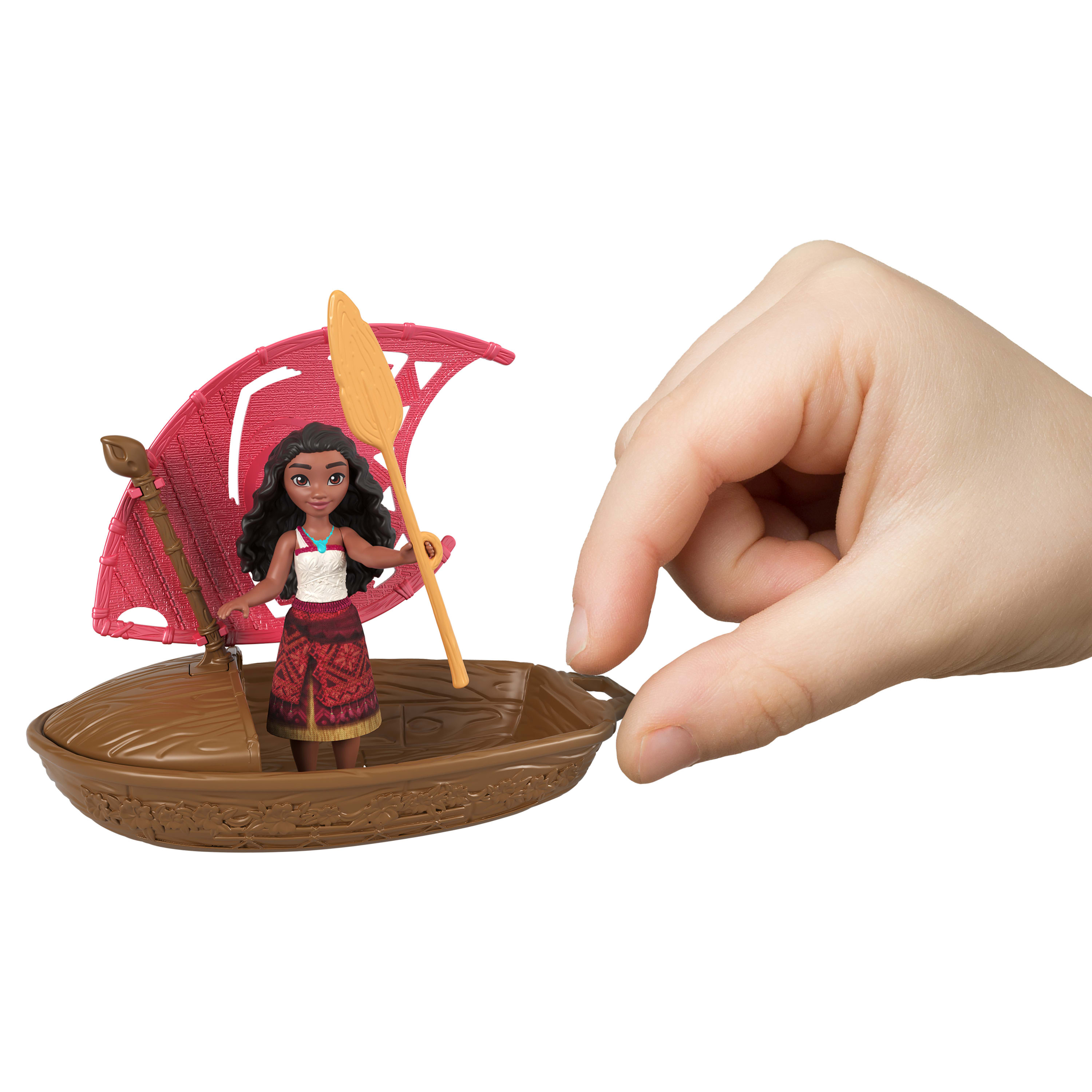 Eine Hand hält ein Spielzeugboot mit einer Moana-Figur und einem Segel. Das Segel ist rot, das Boot ist braun.