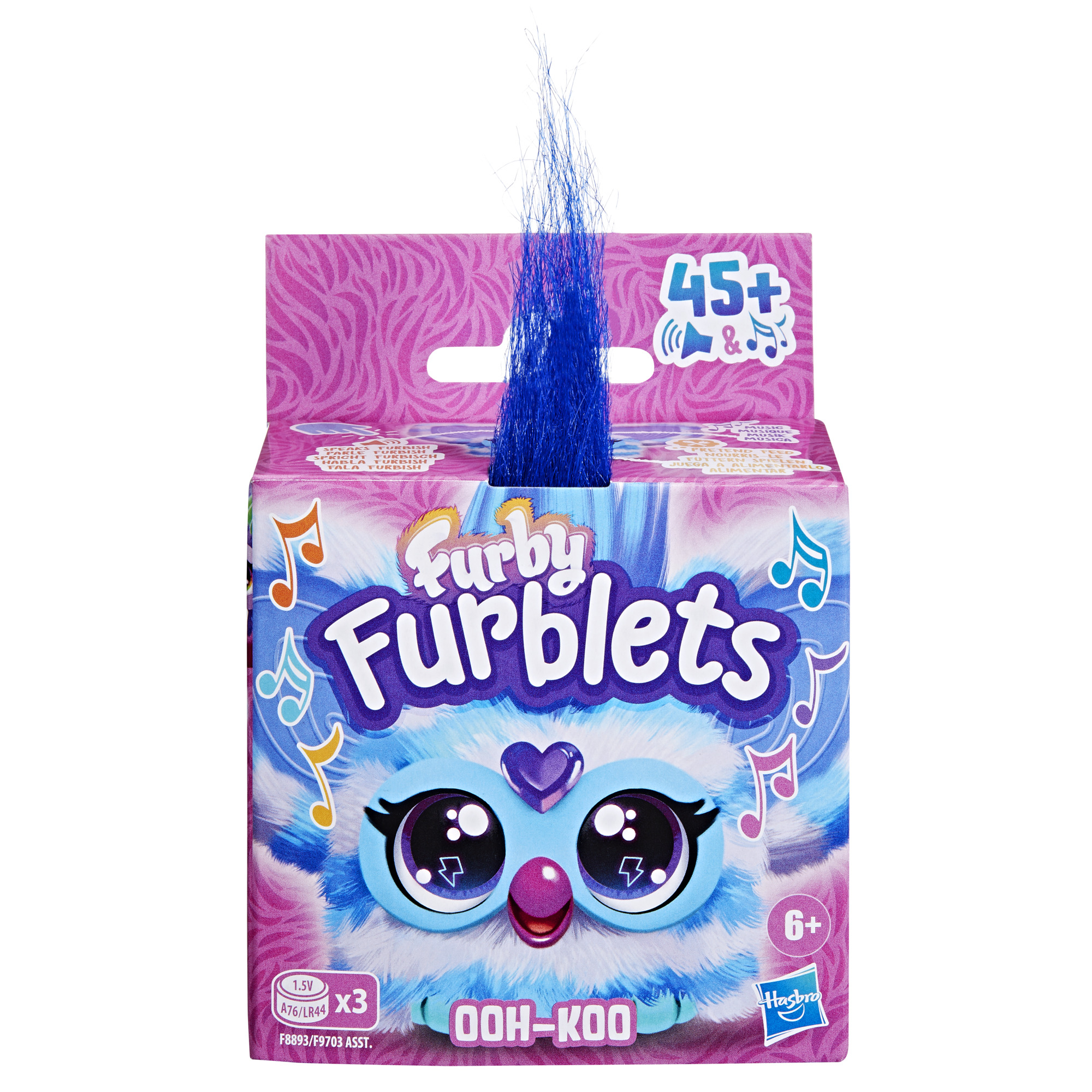 Una caja de Furby Furblets. Tiene una parte superior azul y peluda con una cara de Furby. El fondo es rosa con un patrón ondulado.