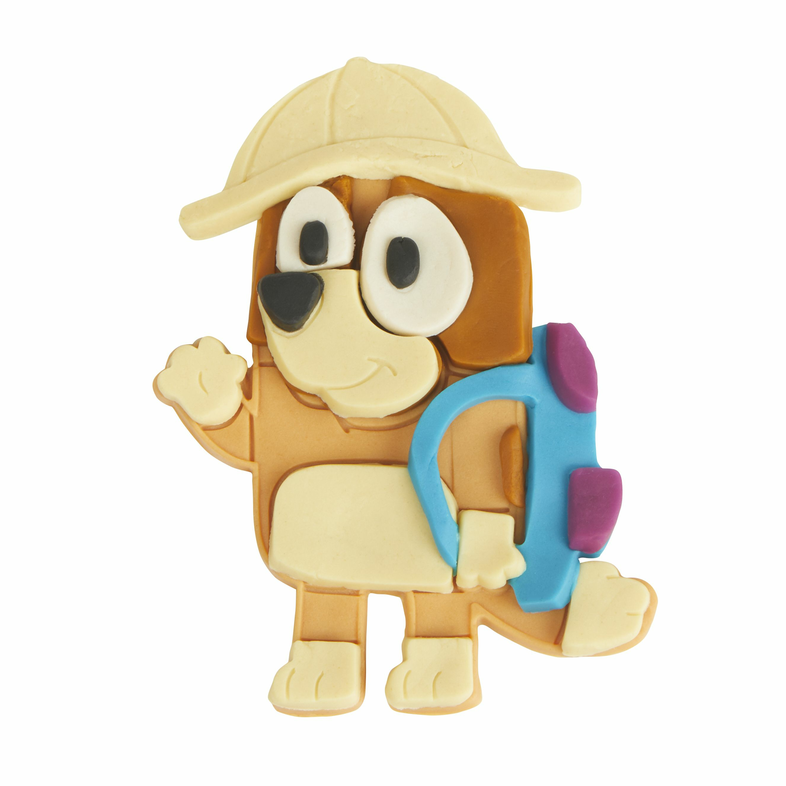Juguete de perro con sombrero y mochila beige. Está saludando con la mano izquierda. El fondo es blanco.