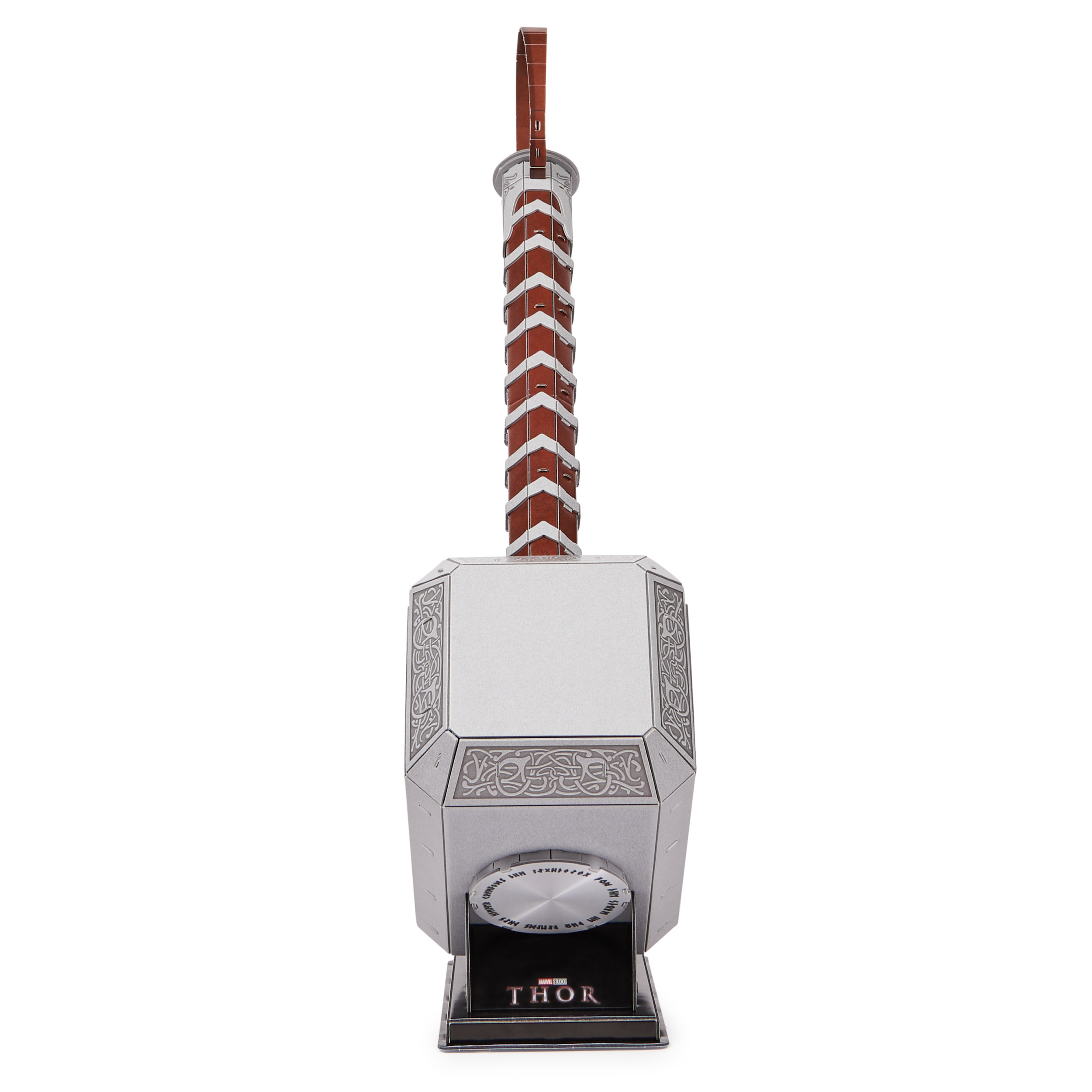 Metalowy model młota Thora. Jest srebrny z brązową rączką. Podstawa ma logo Thora.