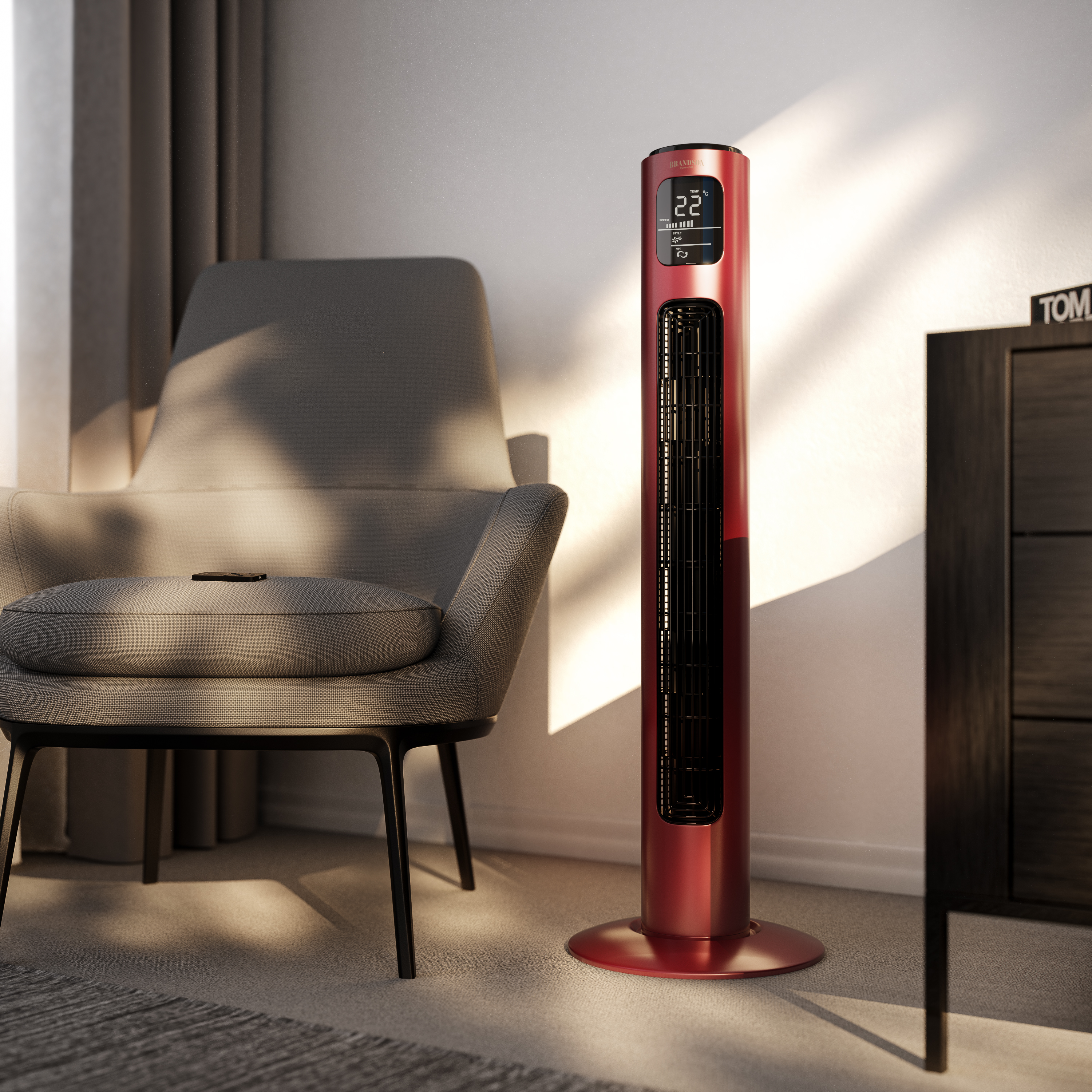 Ein roter Ventilator steht neben einem grauen Sessel. Im Hintergrund befinden sich ein Holzschrank und ein Fenster.