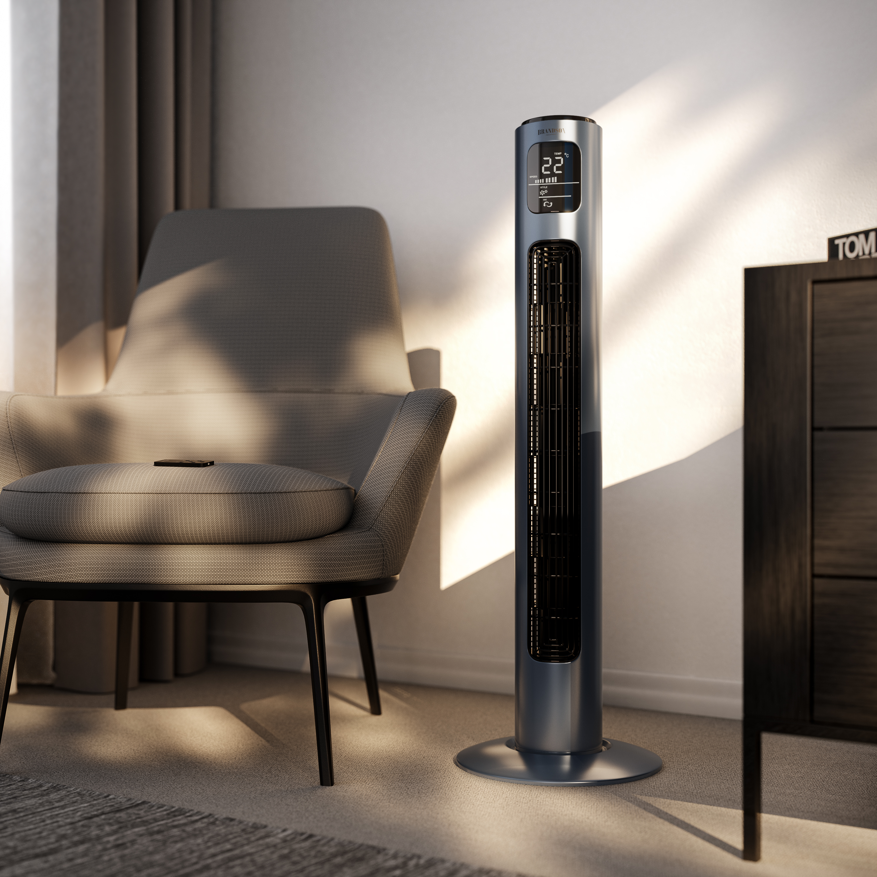 Ein modernes Zimmer mit grauem Ventilator, Stuhl und Schrank. Auf dem Stuhl liegt eine Fernbedienung.