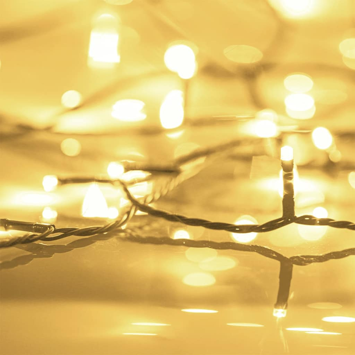 Nahaufnahme von Lichterketten, unscharfer Hintergrund. Warmer gelber Schein mit fokussierten und unscharfen Lichtpunkten.