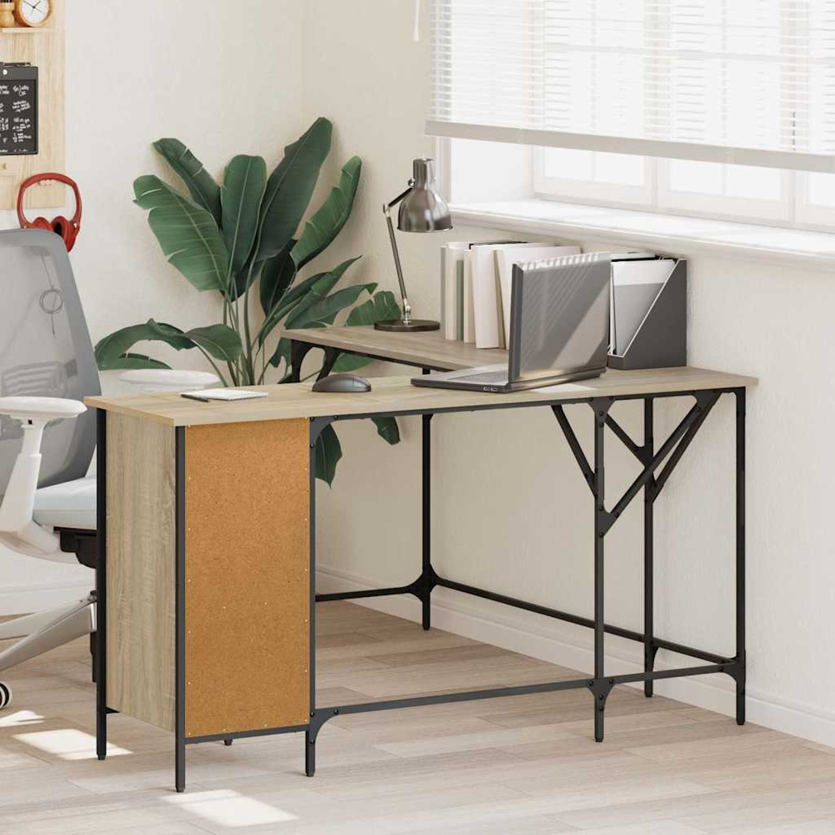 Ein moderner Schreibtisch mit Laptop, Lampe und Akten. Im Hintergrund eine Pflanze und ein Fenster.