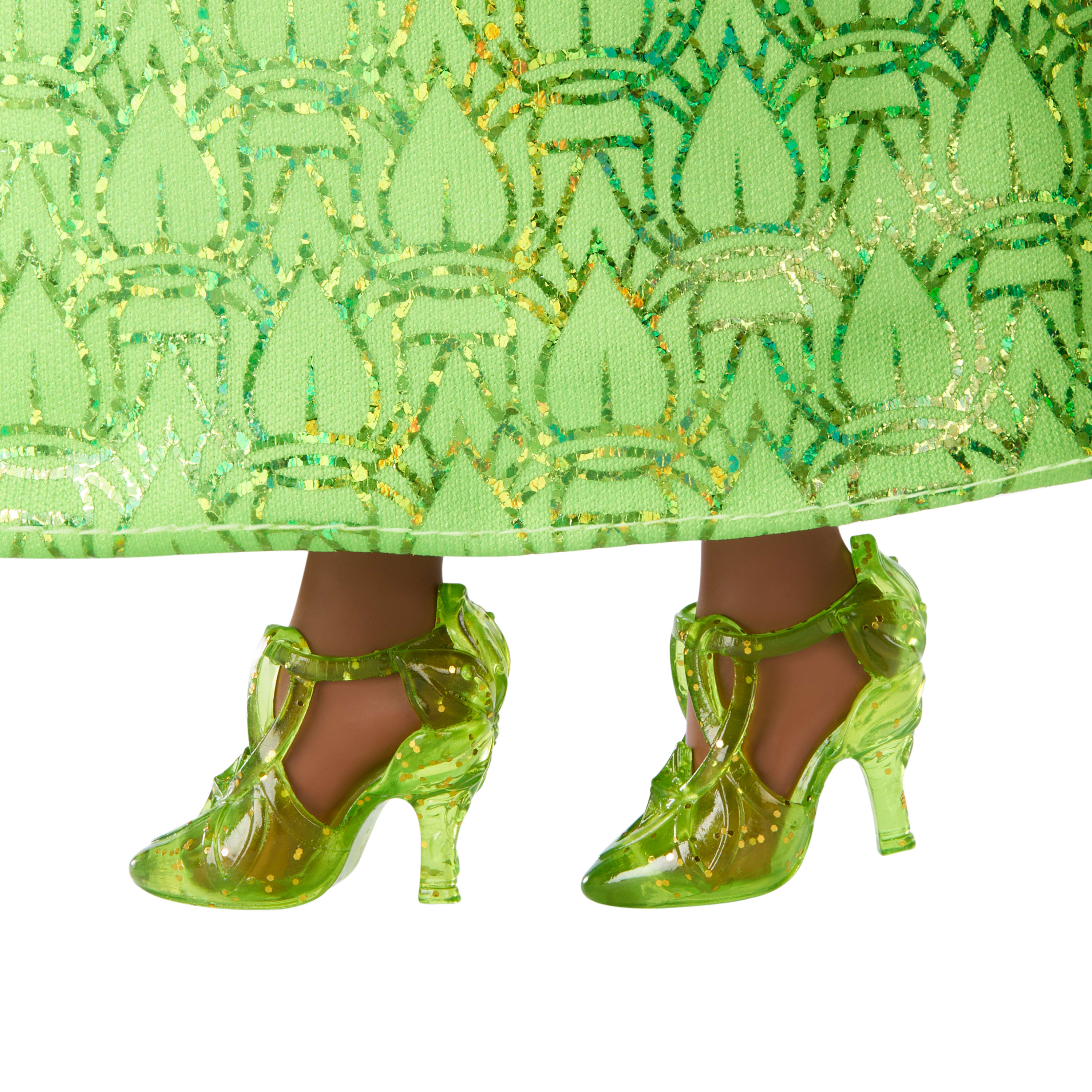Zielona sukienka i buty na lalce. Sukienka ma błyszczące wzory. Buty to przezroczyste zielone obcasy.