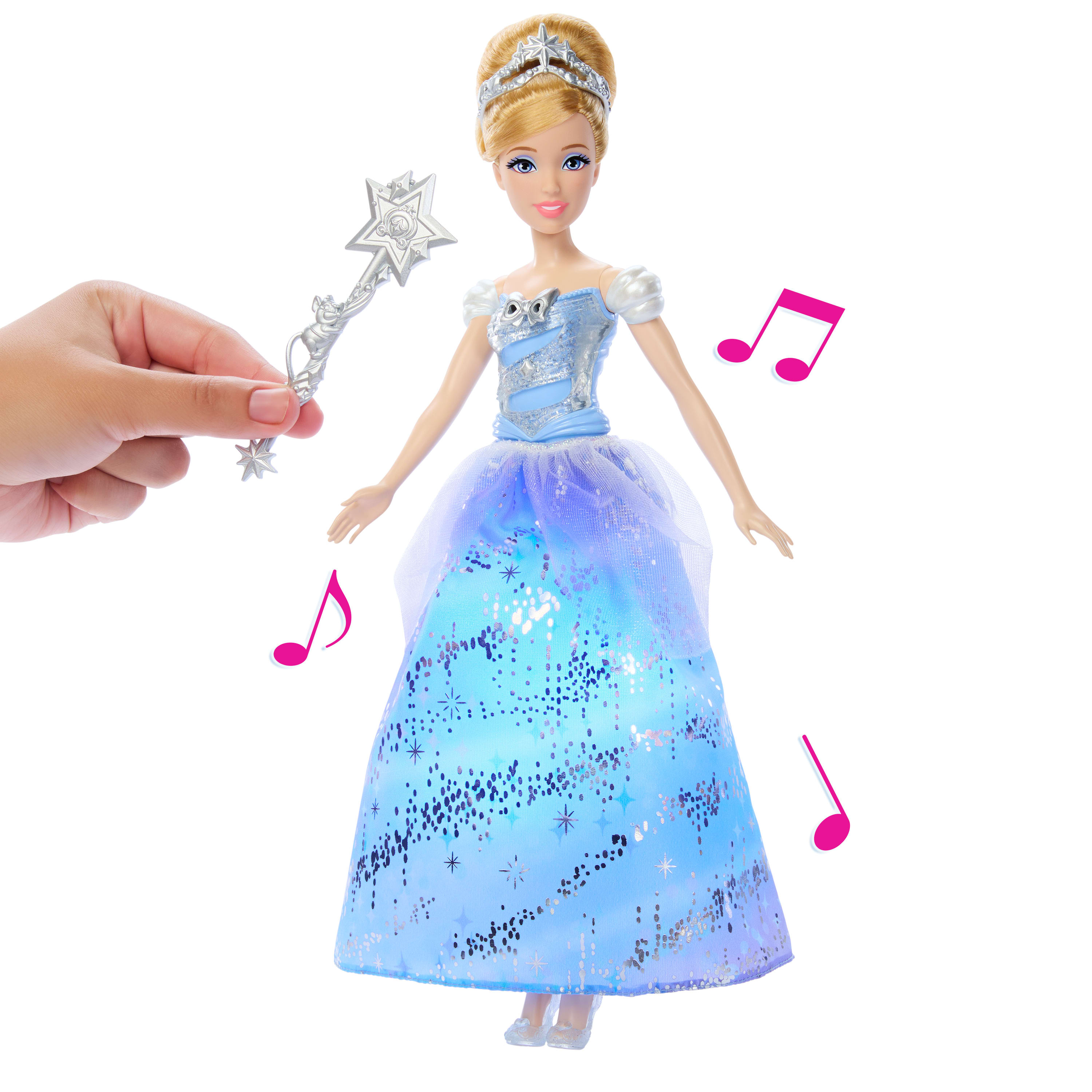 Cinderella-Puppe in blauem Kleid, mit Tiara und Zauberstab. Pinke Noten um die Puppe herum.