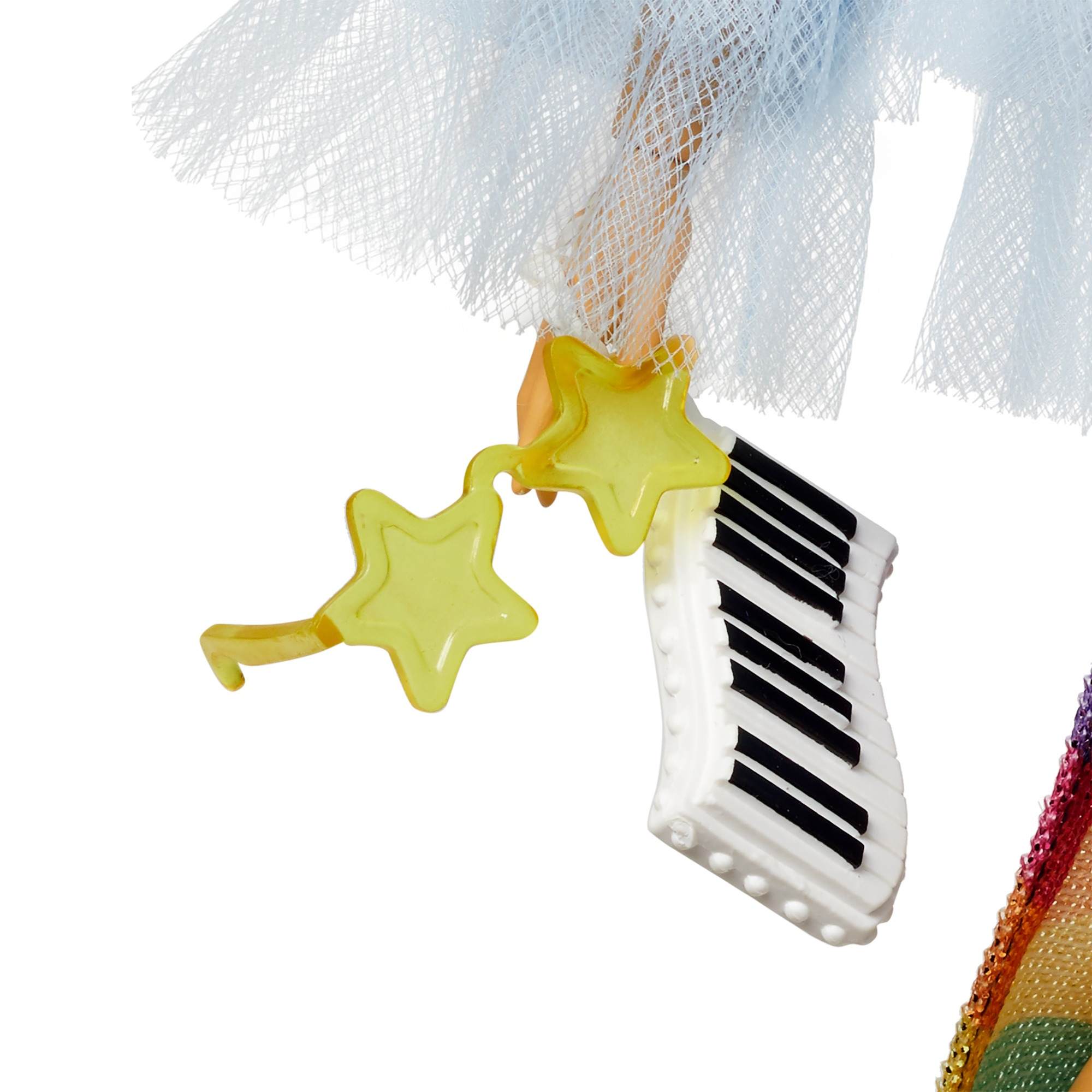 Zbliżenie zabawki z klawiszami pianina, dwiema żółtymi gwiazdami i niebieską tkaniną na białym tle.