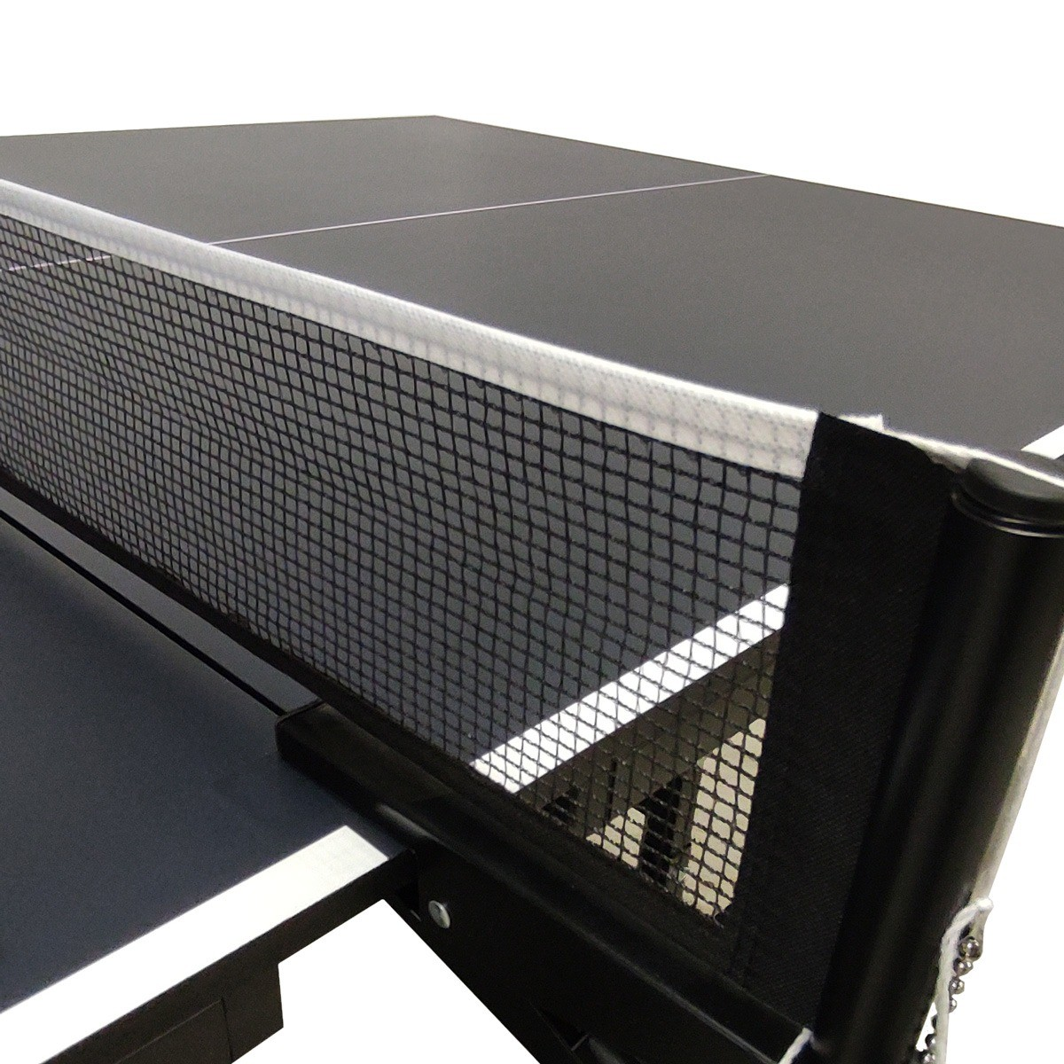 A close-up of a ping pong table. The net is in focus, with a black and gray table. The net is white at the top and black.