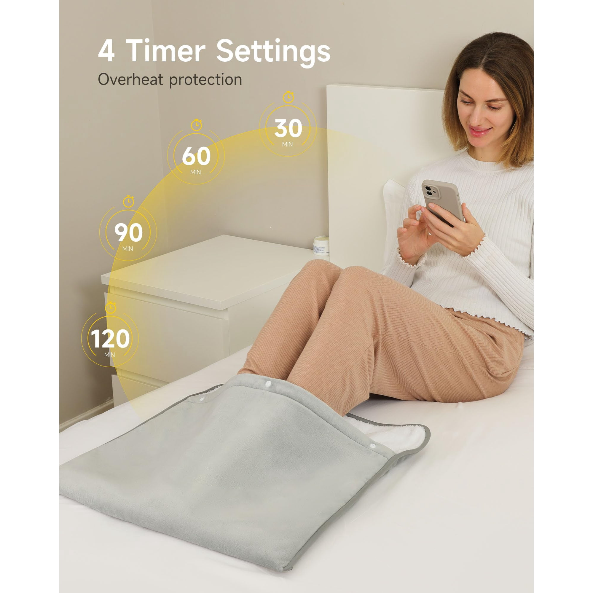 Frau benutzt Telefon, während ihre Füße in einem grauen Heizkissen auf einem Bett liegen. Timer-Einstellungen: 30, 60, 90, 120 Minuten.