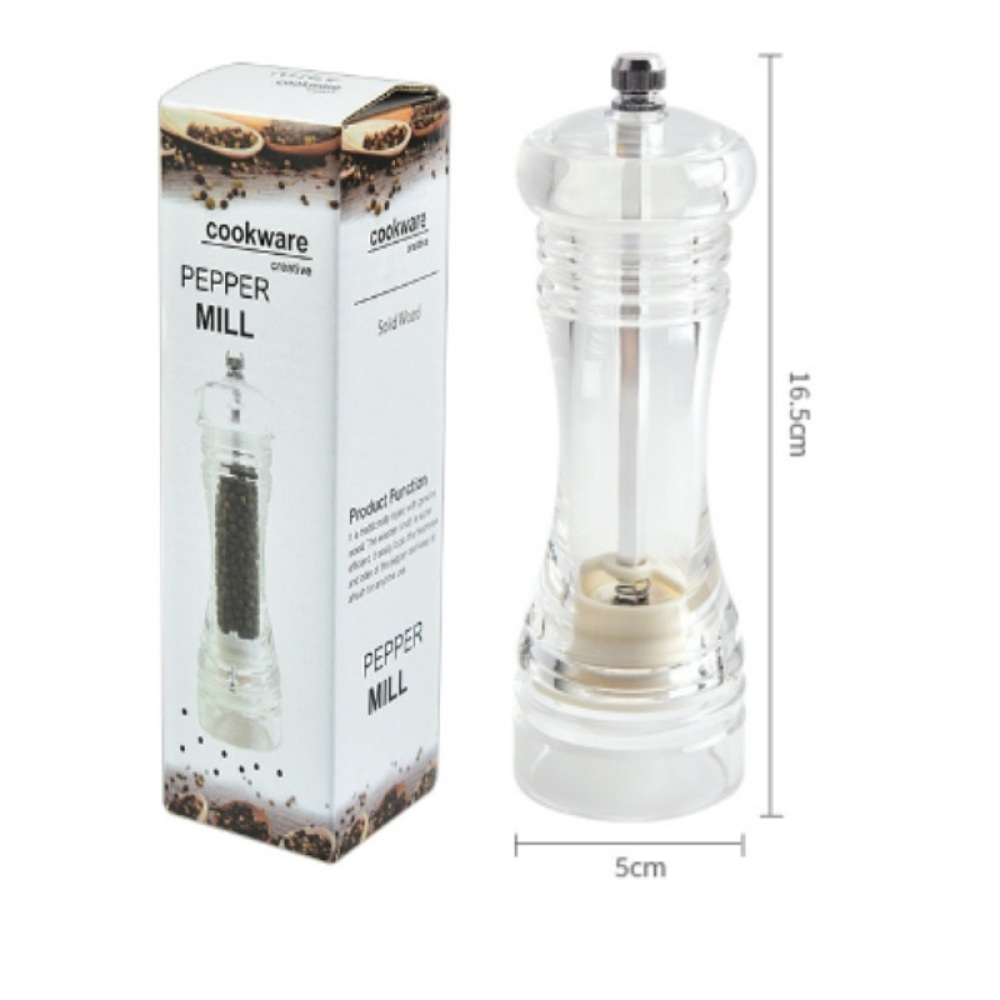 Eine transparente Pfeffermühle neben ihrer Verpackung. Die Mühle zeigt den Pfeffer im Inneren. Die Box hat das Bild der Mühle und Pfeffer.