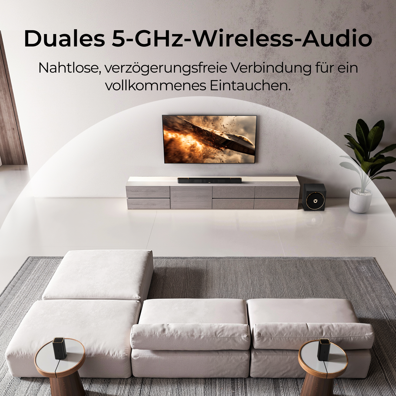 Ein modernes Wohnzimmer mit Fernseher, Soundbar und Subwoofer. Ein weißes Ecksofa und zwei Beistelltische im Vordergrund.