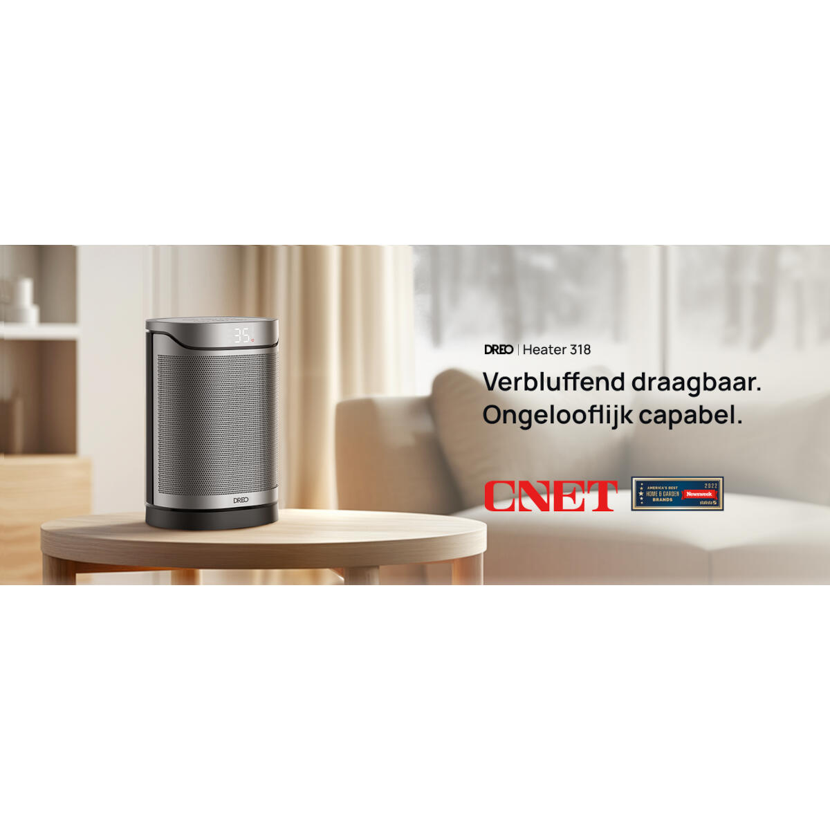 Een zilveren en zwarte DREO-verwarming op een houten tafel. Een bank op de achtergrond, een CNET-logo en een Newsweek-badge.