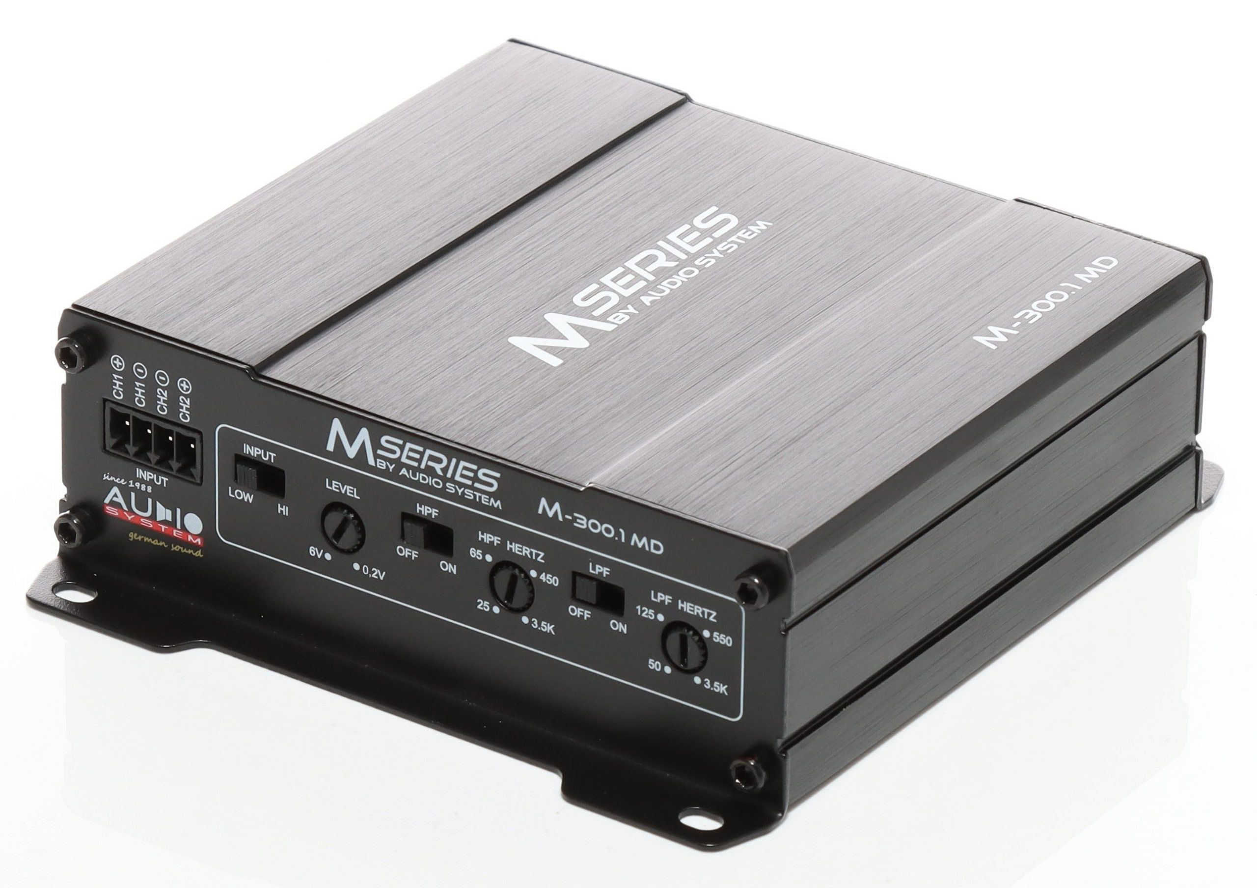 Ein schwarzer Auto-Audio-Verstärker. Er hat Bedienelemente, Eingänge und den Markennamen M Series. Auf weißem Untergrund.