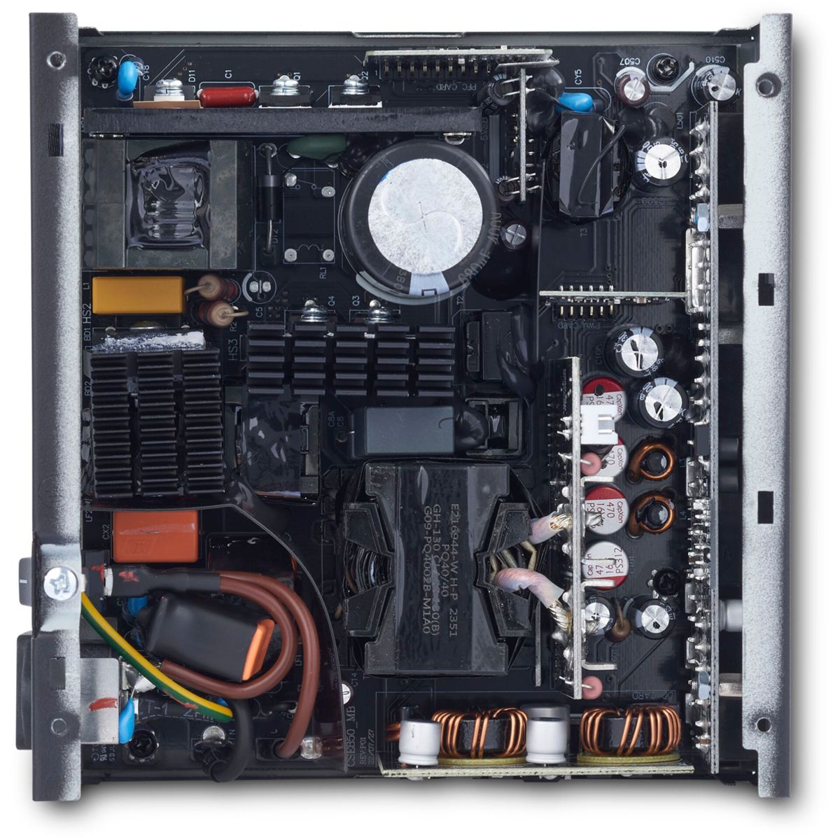 Draufsicht auf das Innere eines Computer-Netzteils mit verschiedenen Komponenten wie Kondensatoren, Spulen und einem Kühlkörper.
