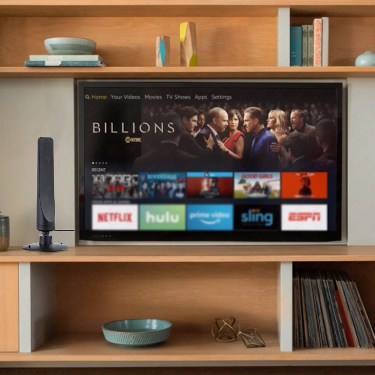 Ein Fernseher zeigt die Sendung 'Billions'. Links steht eine Antenne. Der Fernseher steht auf einem Holzregal mit anderen Gegenständen.