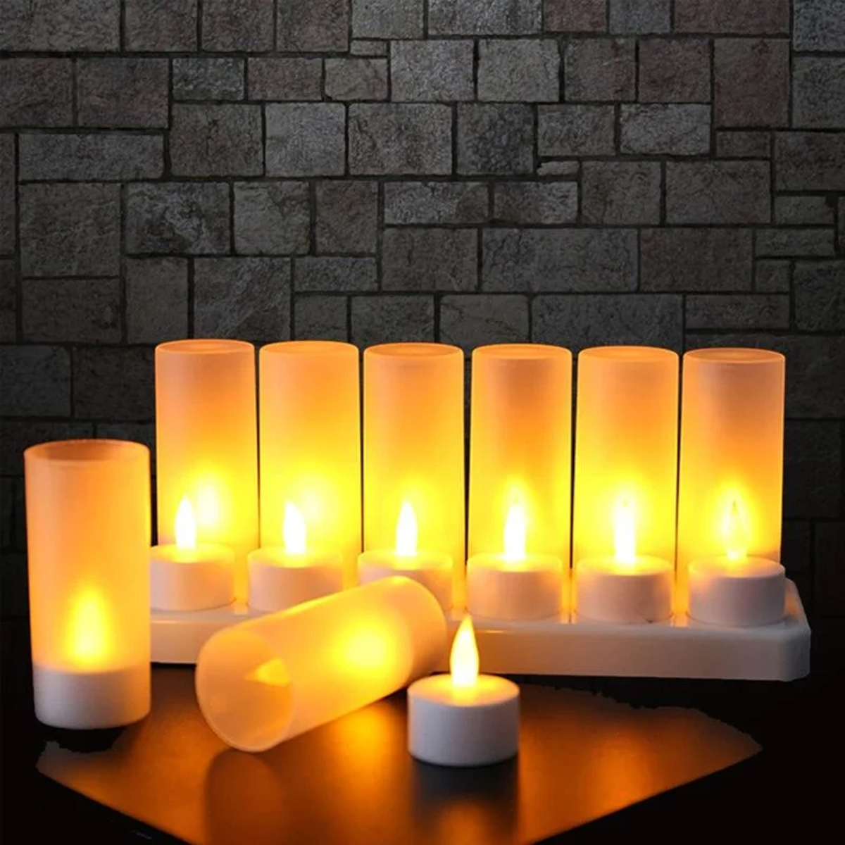 Sette candele LED luminose nei supporti. Una candela è sul tavolo, un'altra è caduta. Un muro di mattoni sullo sfondo.