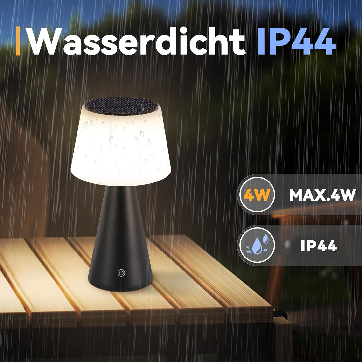 Una lámpara de mesa negra con una pantalla blanca está sobre una mesa de madera. El fondo muestra lluvia y texto en alemán: Wasserdicht IP44.