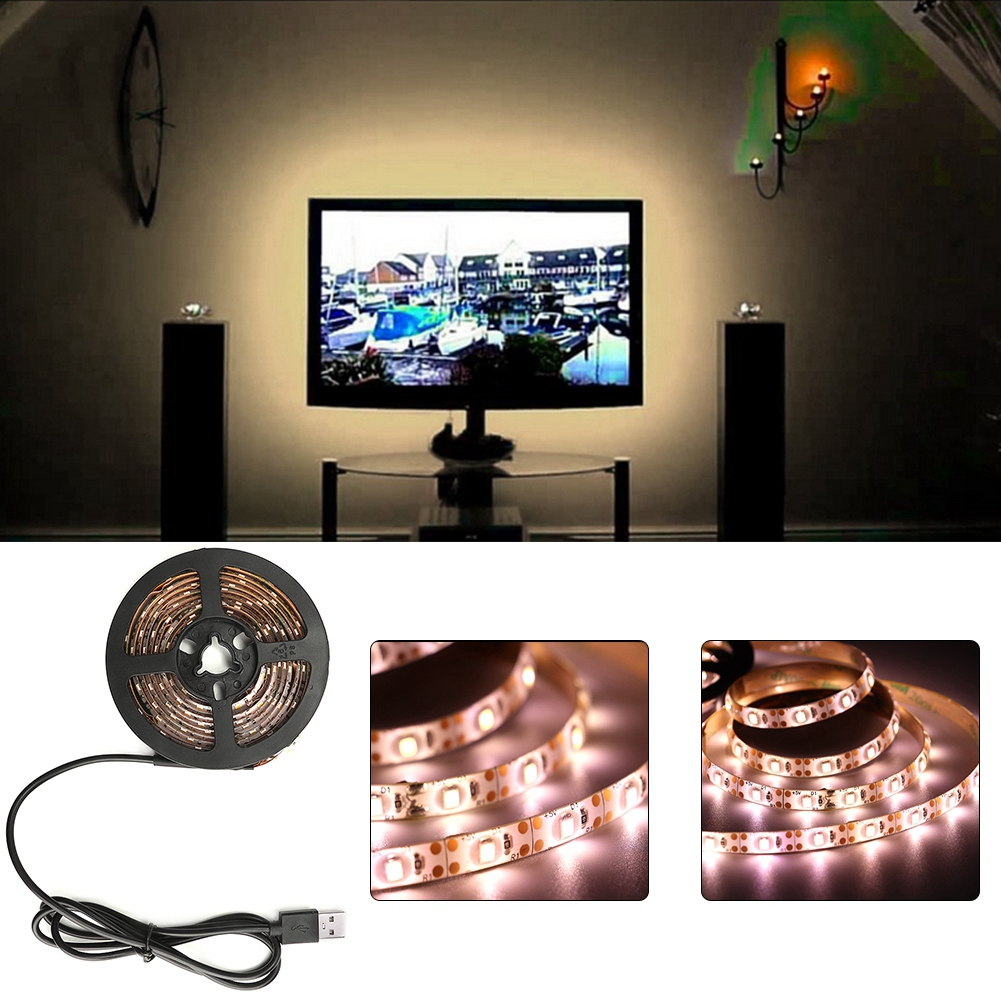 Ein Fernseher mit Booten, Lautsprechern, LED-Streifen und einer Wanduhr. Die Lichter sind warm.