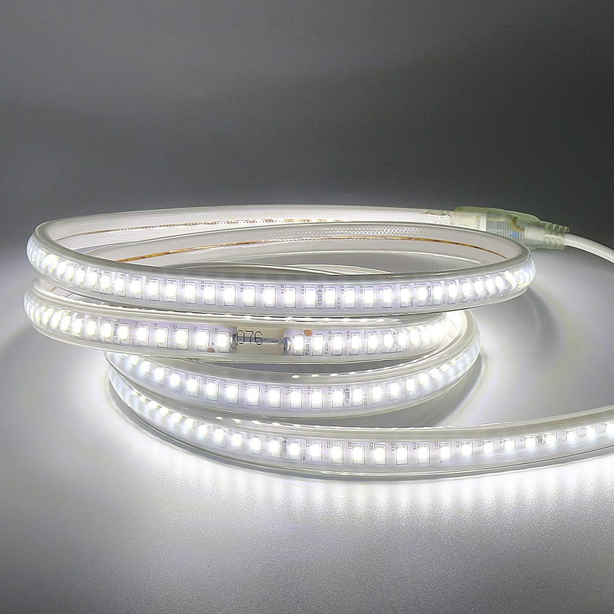 Ein aufgerolltes LED-Band leuchtet. Der Streifen ist weiß mit hellen Lichtern. Ein weißes Kabel ist angebracht.