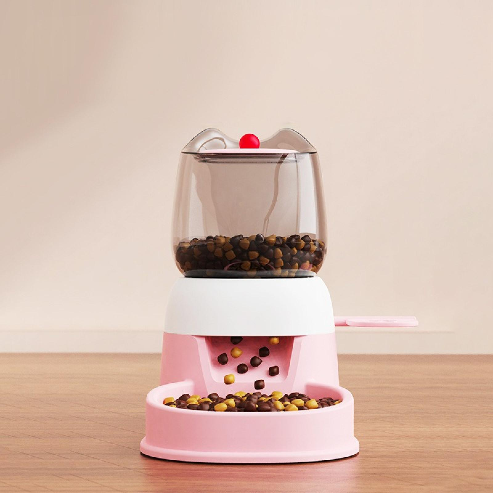 Ein rosa, katzenförmiger Futterautomat mit Futter. Der transparente Behälter enthält Futterpellets, die in die Schüssel darunter gelangen.