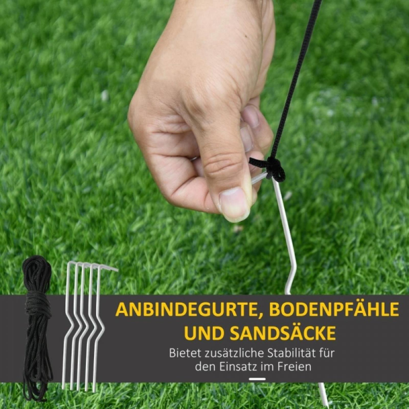 Hand hält ein schwarzes Seil, das mit einem Metallpflock auf grünem Gras verbunden ist. Text: 'ANBINDEGURTE, BODENPFÄHLE UND SANDSÄCKE'.