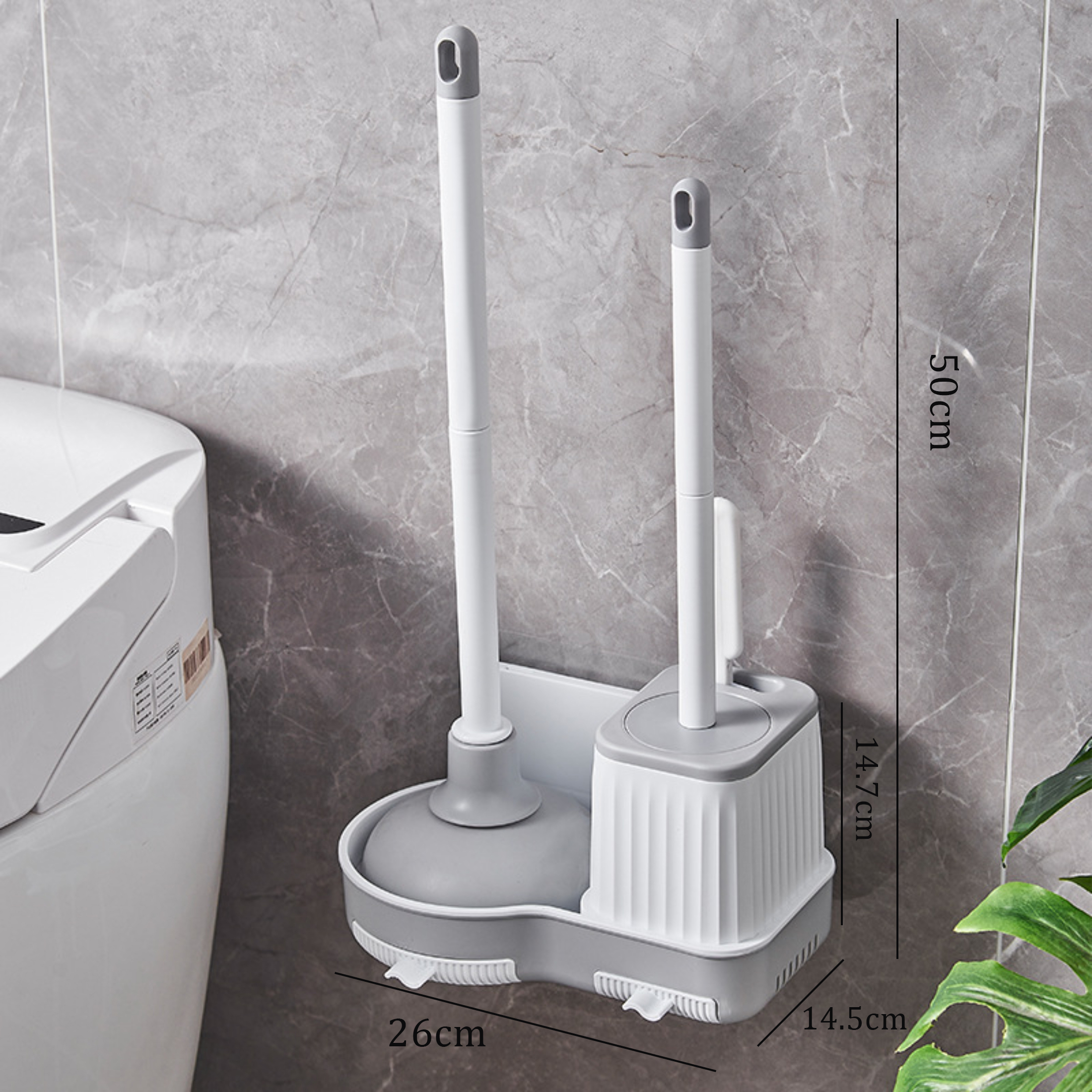 Ein weiß-graues Toilettenbürstenset ist an einer grau marmorierten Wand neben einer weißen Toilette befestigt. Grüne Blätter sind in der Ecke.