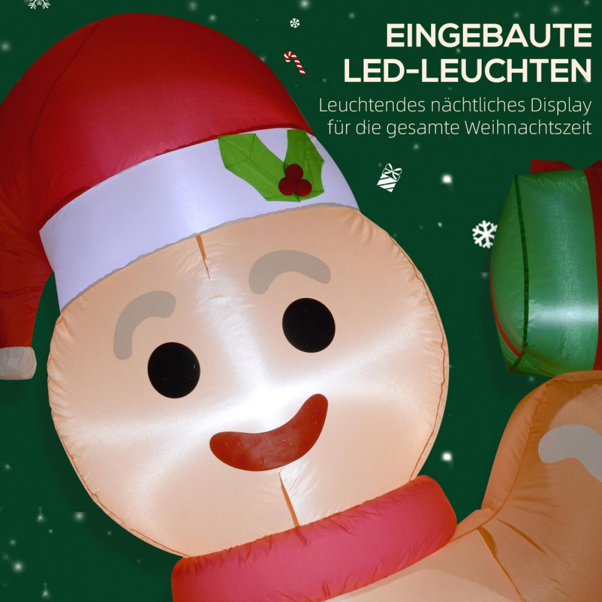 Aufblasbarer Lebkuchenmann mit roter Mütze und Schal. Grüne Geschenkbox im Hintergrund, festliche Weihnachtsdekoration.