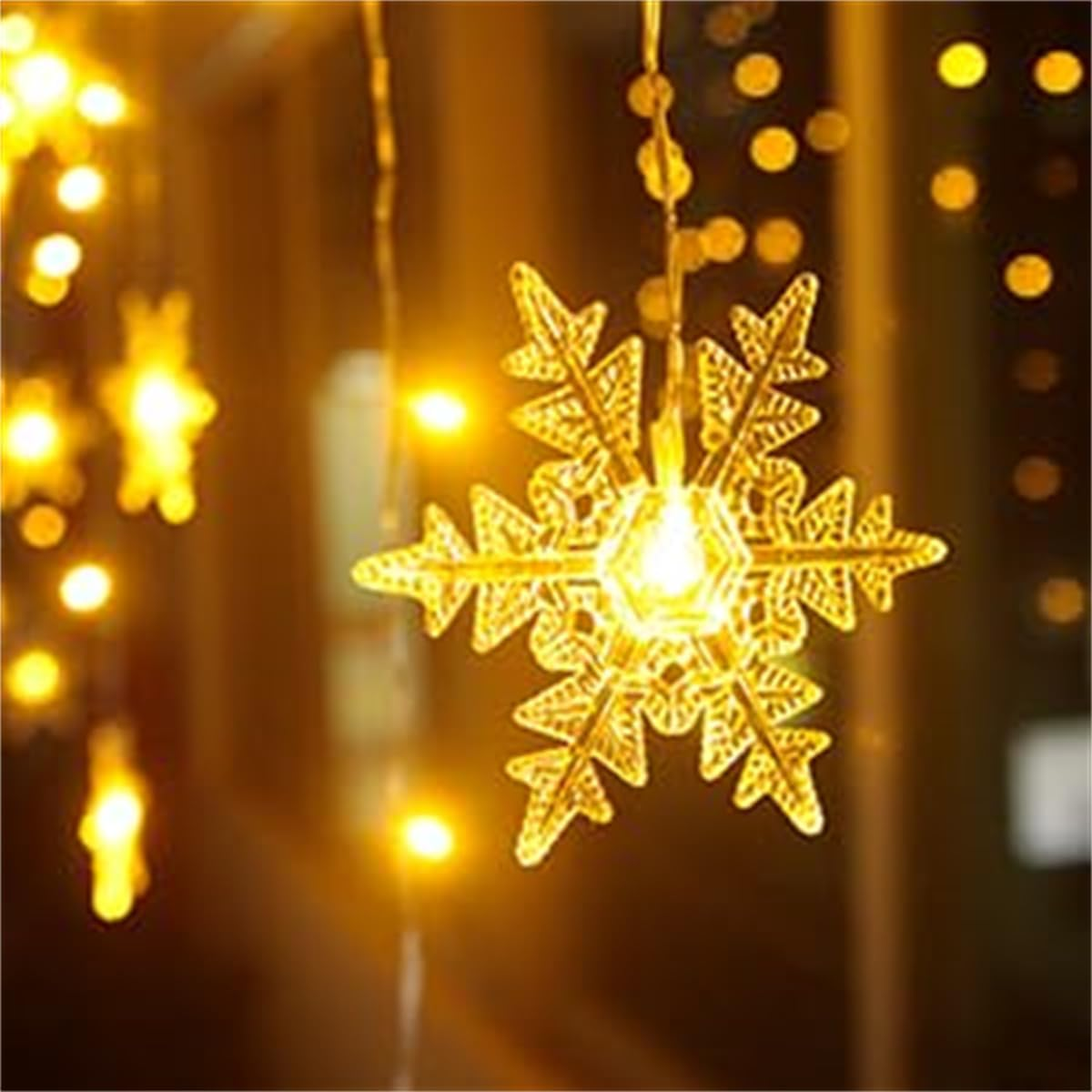 Eine leuchtende, schneeflockenförmige Leuchte hängt. Im Hintergrund befinden sich weitere warme Lichter. Die Szene wird von den Lichtern beleuchtet.