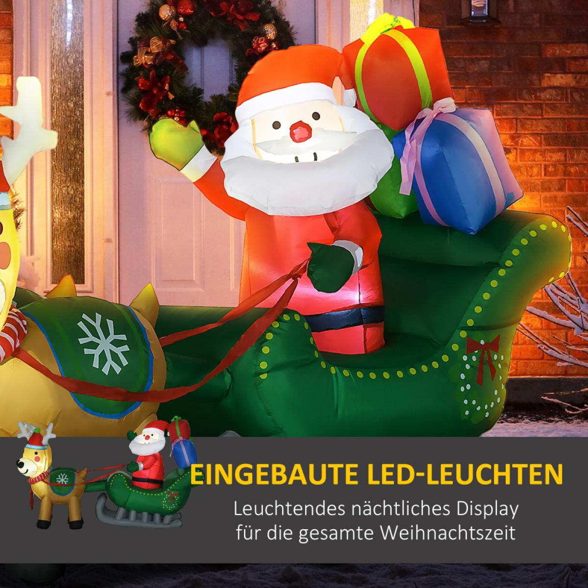 Aufblasbarer Weihnachtsmann auf einem grünen Schlitten mit Geschenken, gezogen von einem Rentier, vor einem Hauseingang mit Kranz.
