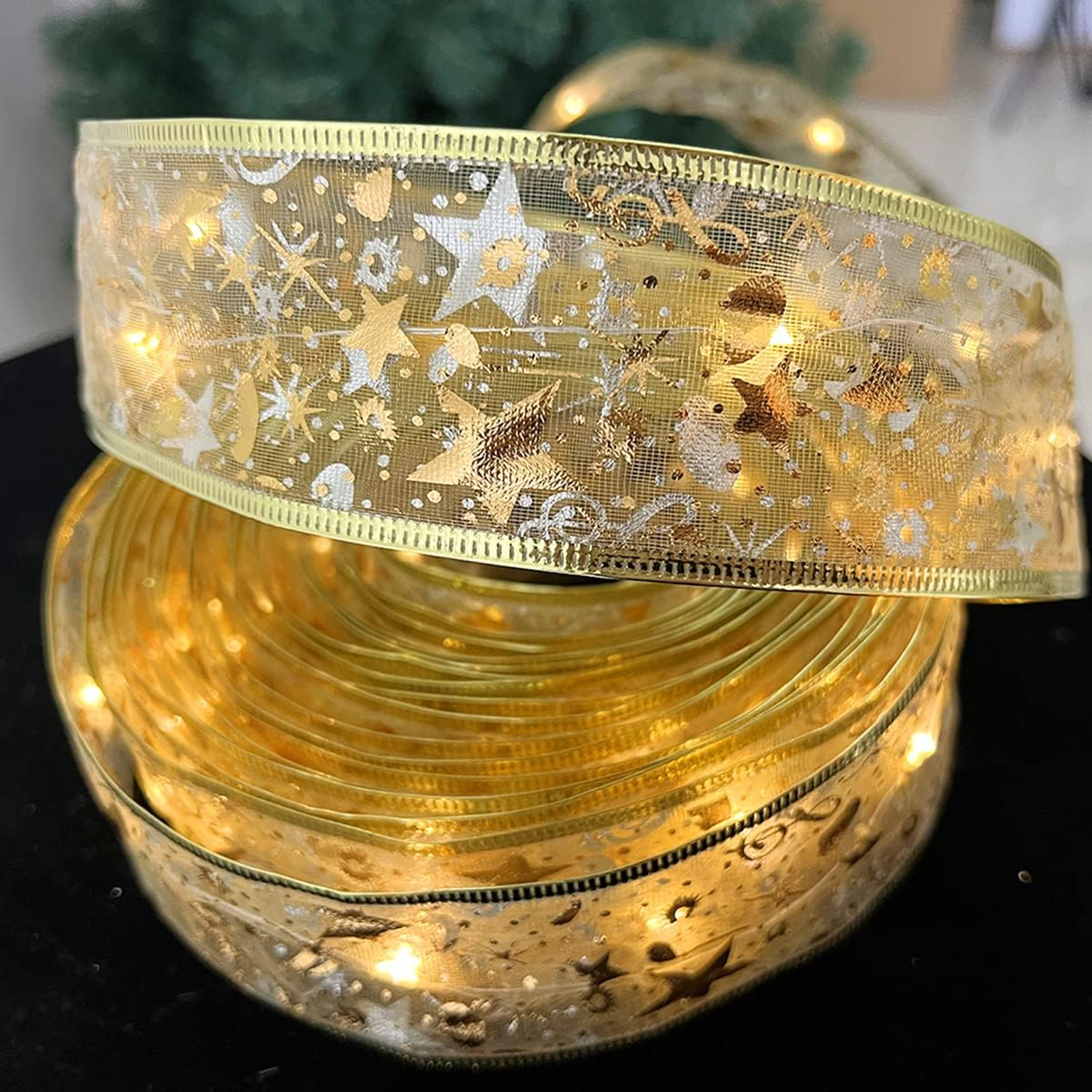 Goldenes Band mit Sternen und Lichtern. Aufgerollt, mit einer zweiten Schicht darüber. Grüner Hintergrund.
