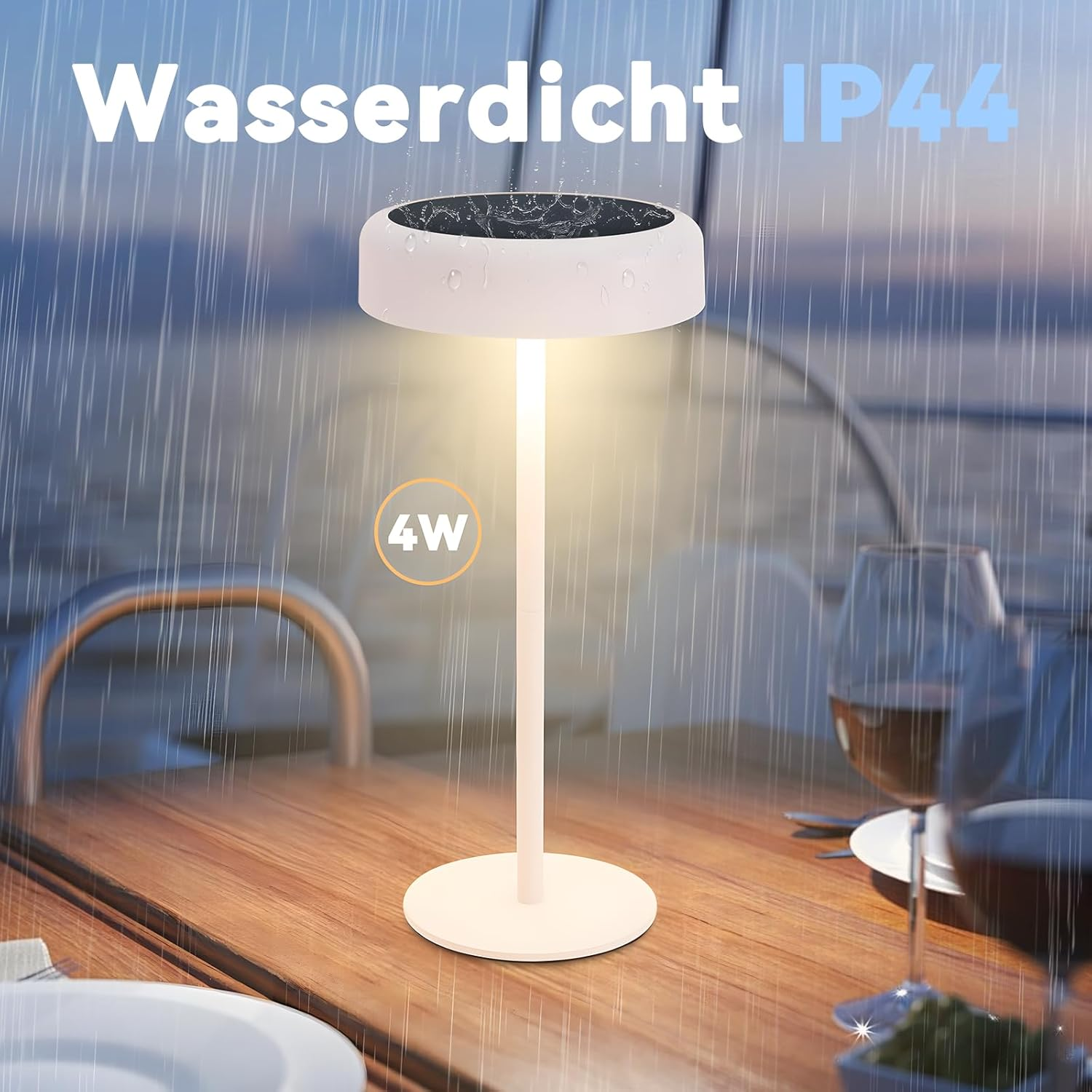 Una lampada bianca su un tavolo di legno, sotto la pioggia. Bicchieri e piatti sono anche sul tavolo. Testo: Wasserdicht IP44 4W.