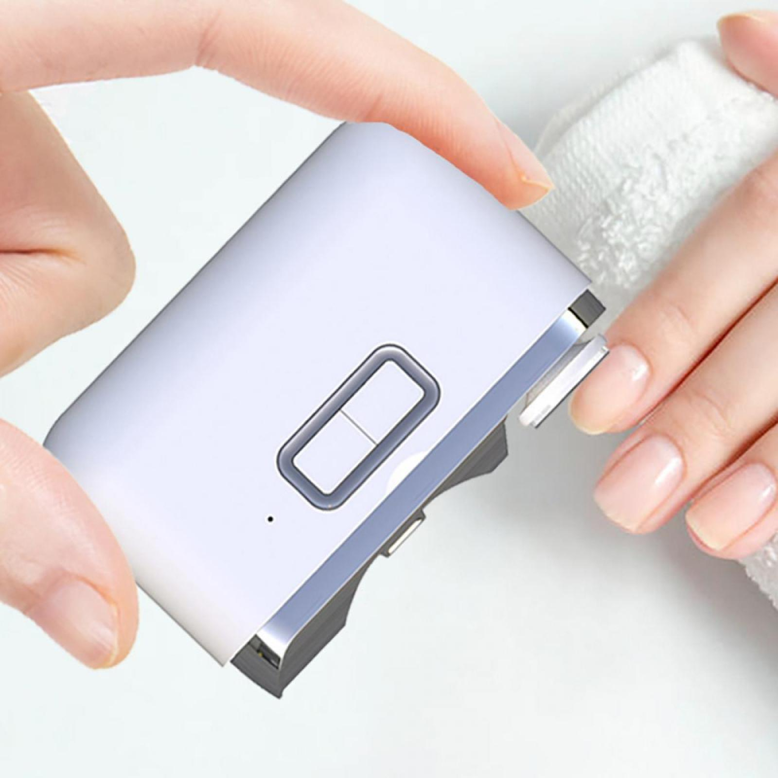 Ein weißer Nageltrimmer wird von zwei Händen gehalten. Eine Hand schneidet einen Nagel. Im Hintergrund befindet sich ein weißes Handtuch.