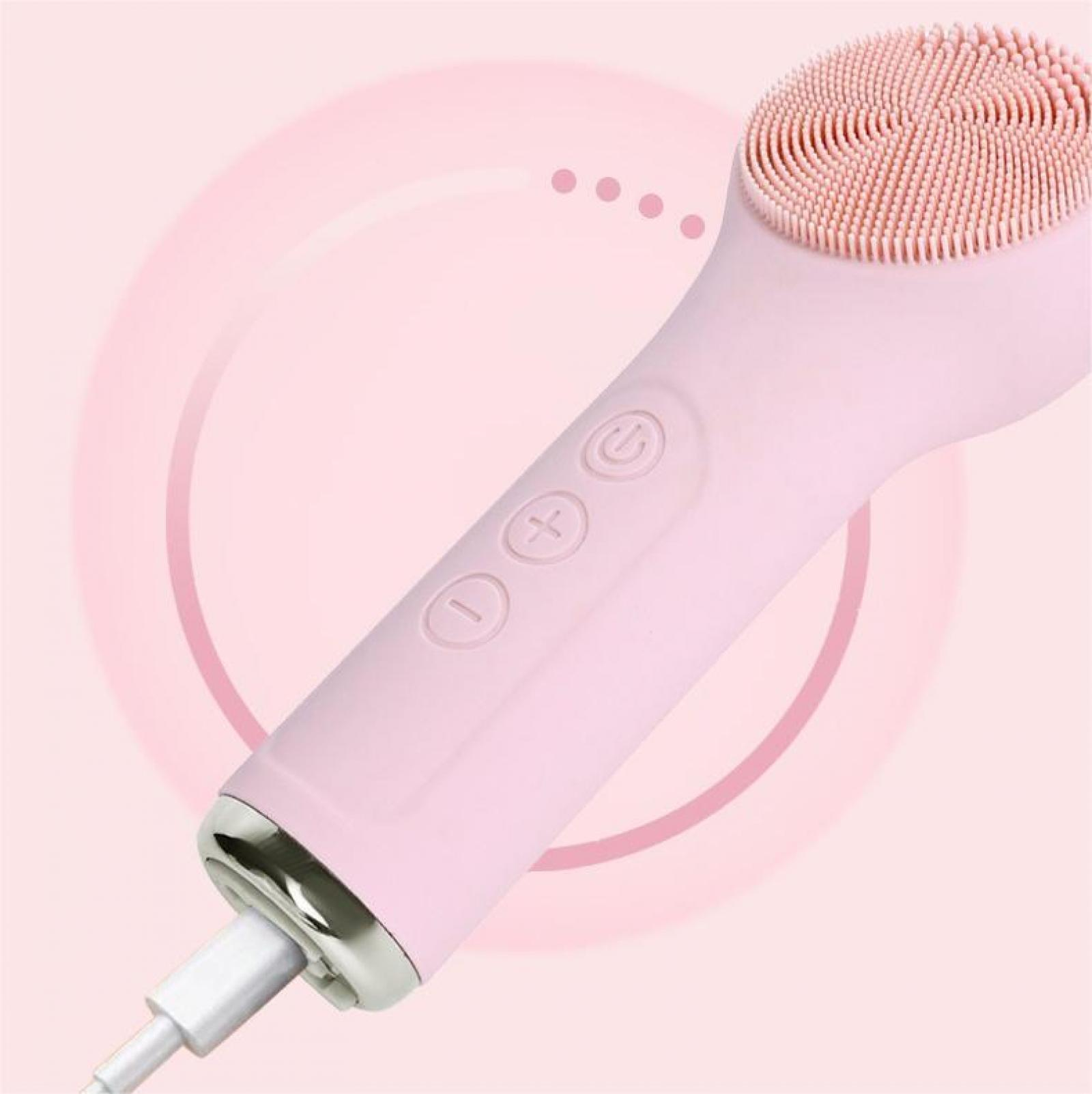 Eine rosa Gesichtsbürste mit strukturiertem Kopf, Knöpfen und einem Ladekabel vor rosa Hintergrund.