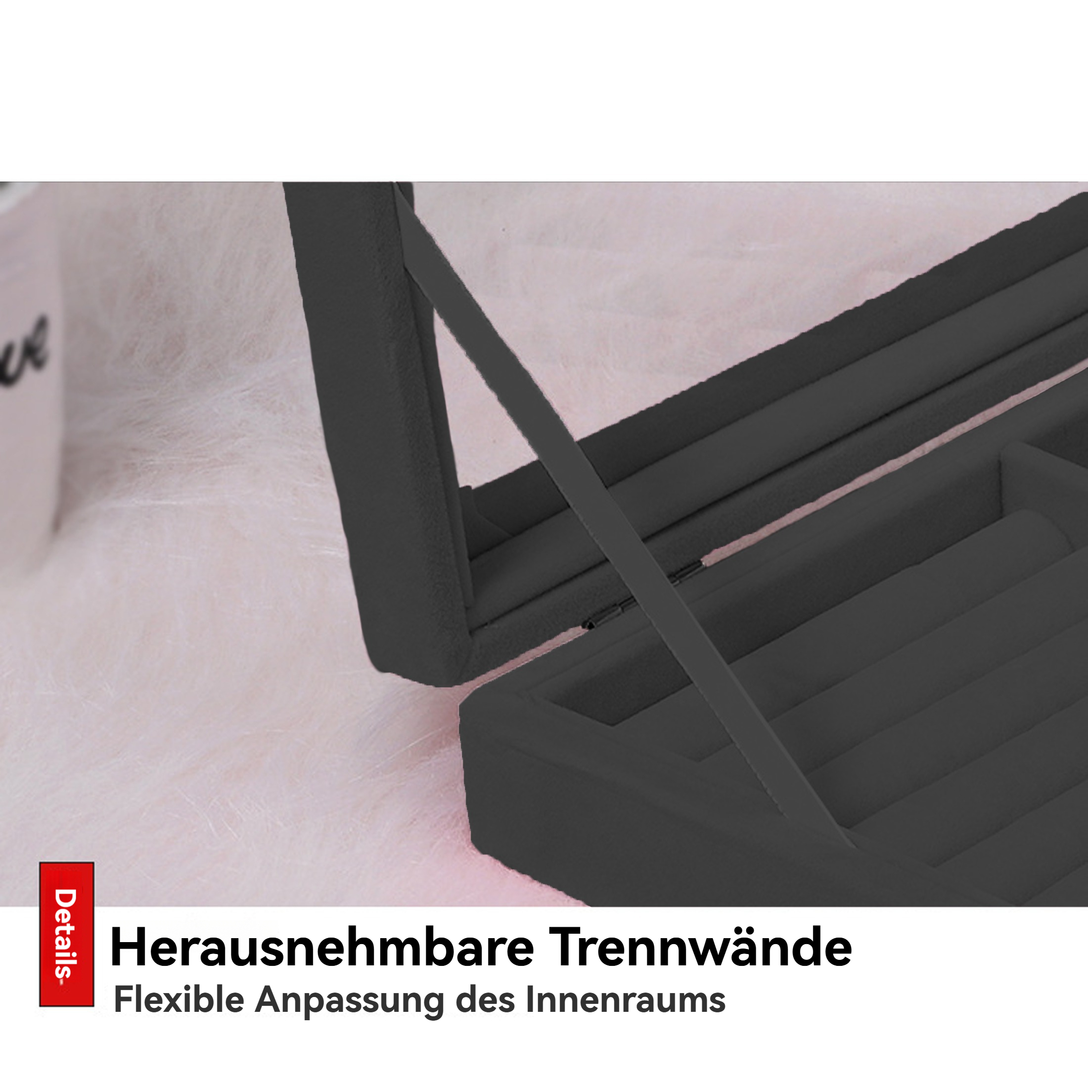 Geöffnete schwarze Schmuckschatulle mit herausnehmbaren Trennwänden, vor weichem rosa Hintergrund. Der Deckel ist offen.