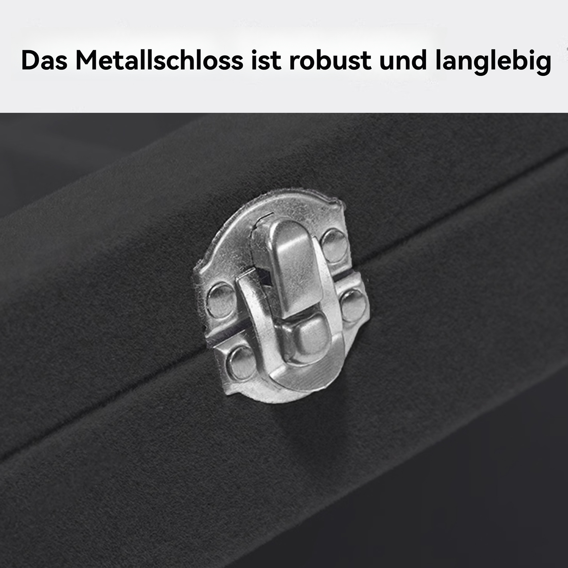 Nahaufnahme eines Metallverschlusses auf dunkler Oberfläche. Der Verschluss ist silber, detailliert. Die Oberfläche ist dunkelgrau, leicht strukturiert.