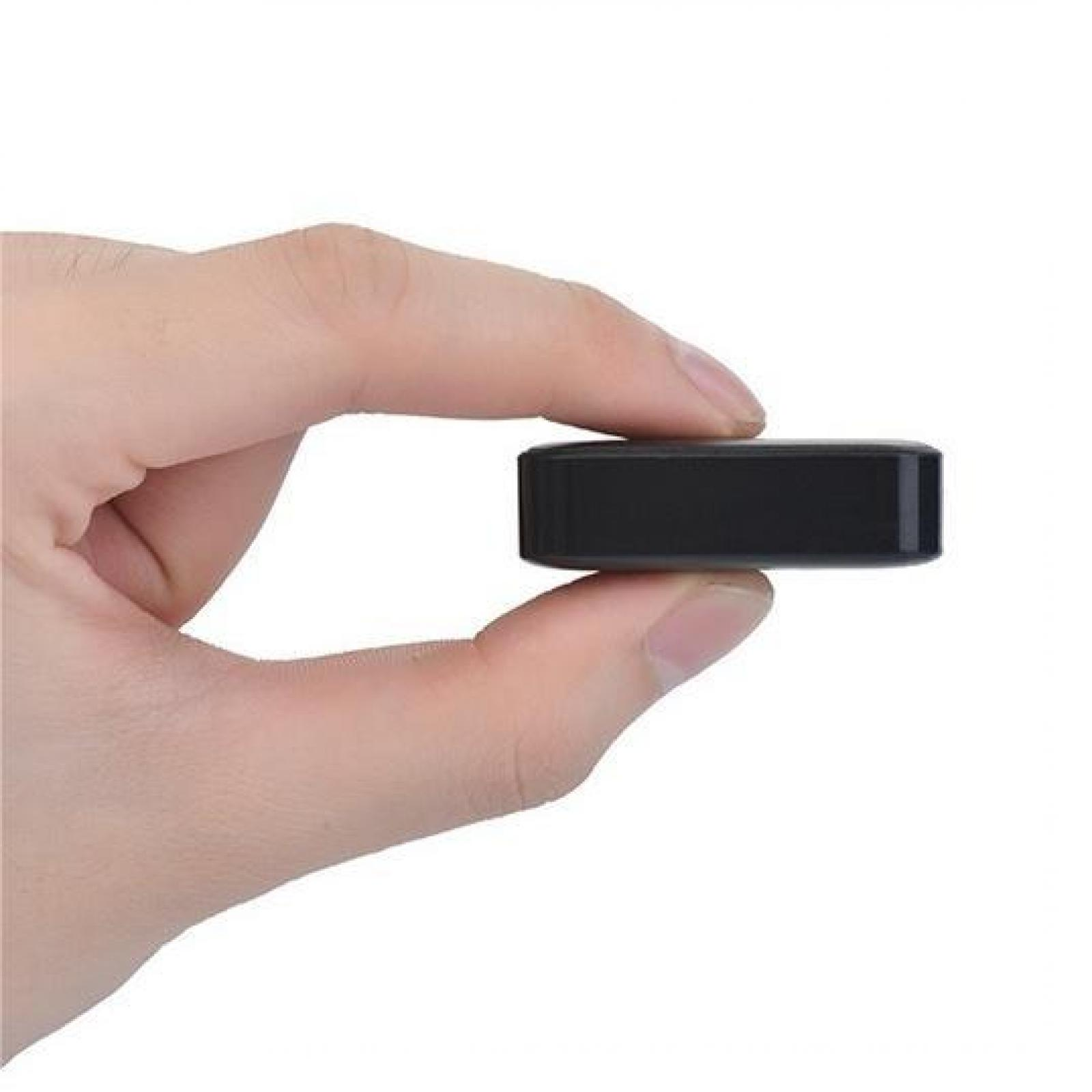 Eine Hand hält ein kleines, schwarzes, rechteckiges Gerät. Finger umfassen das Gerät vor weißem Hintergrund.