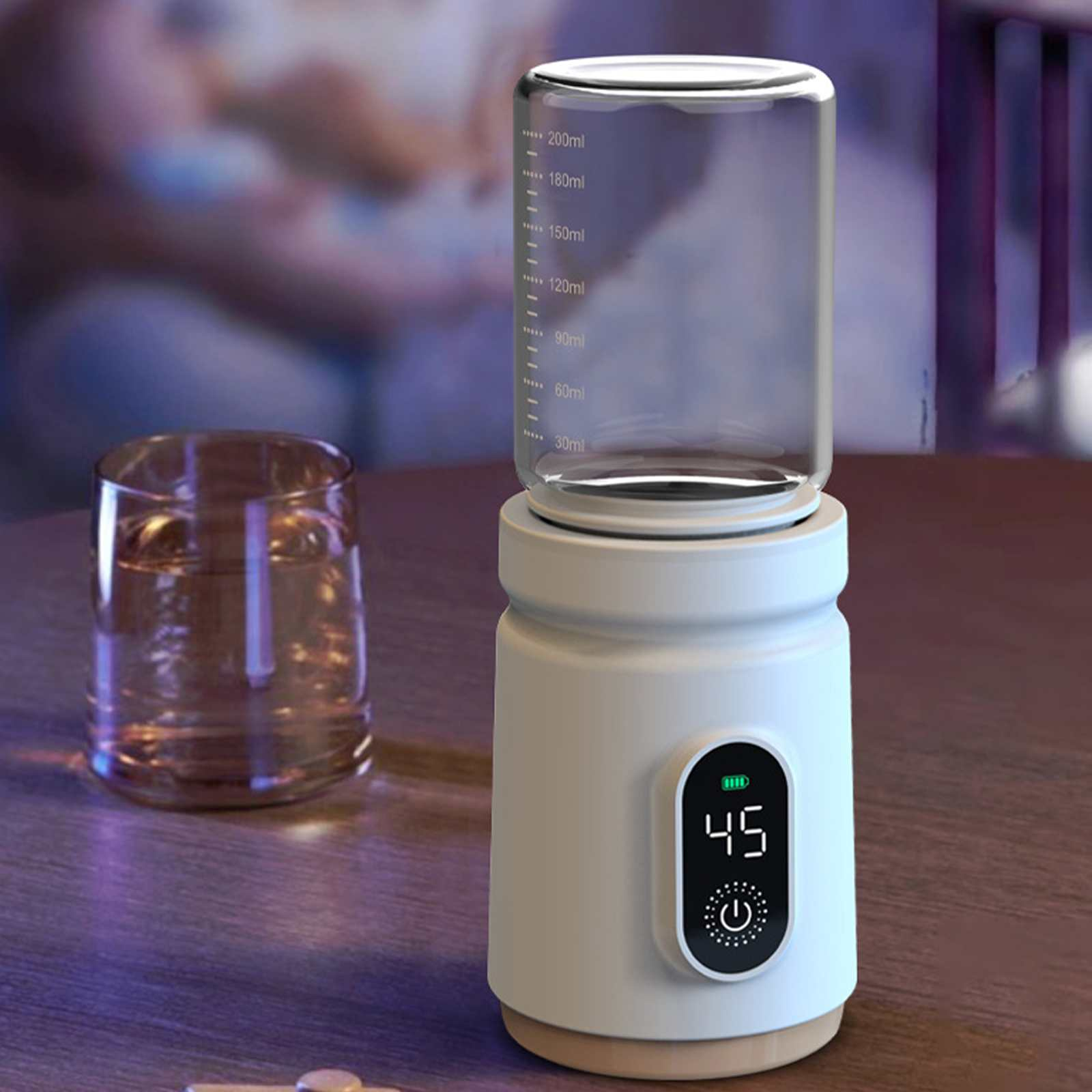 Ein weißer Babyflaschenwärmer mit einem Glasbehälter, einem Glas Wasser und einer Digitalanzeige mit der Zahl 45.