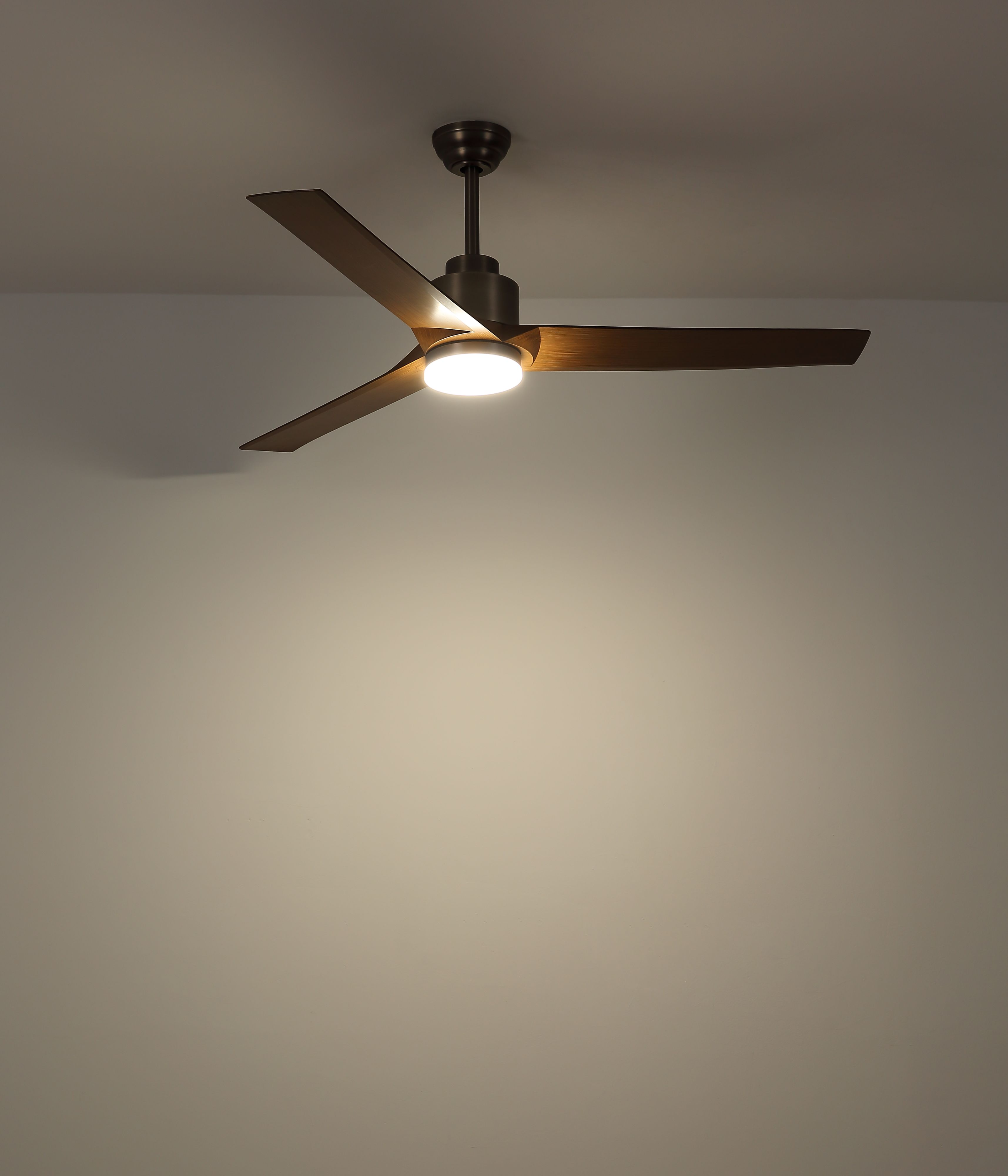 Ein Deckenventilator mit drei Holzblättern und einem zentralen Licht ist an einer hellbeige Decke montiert.