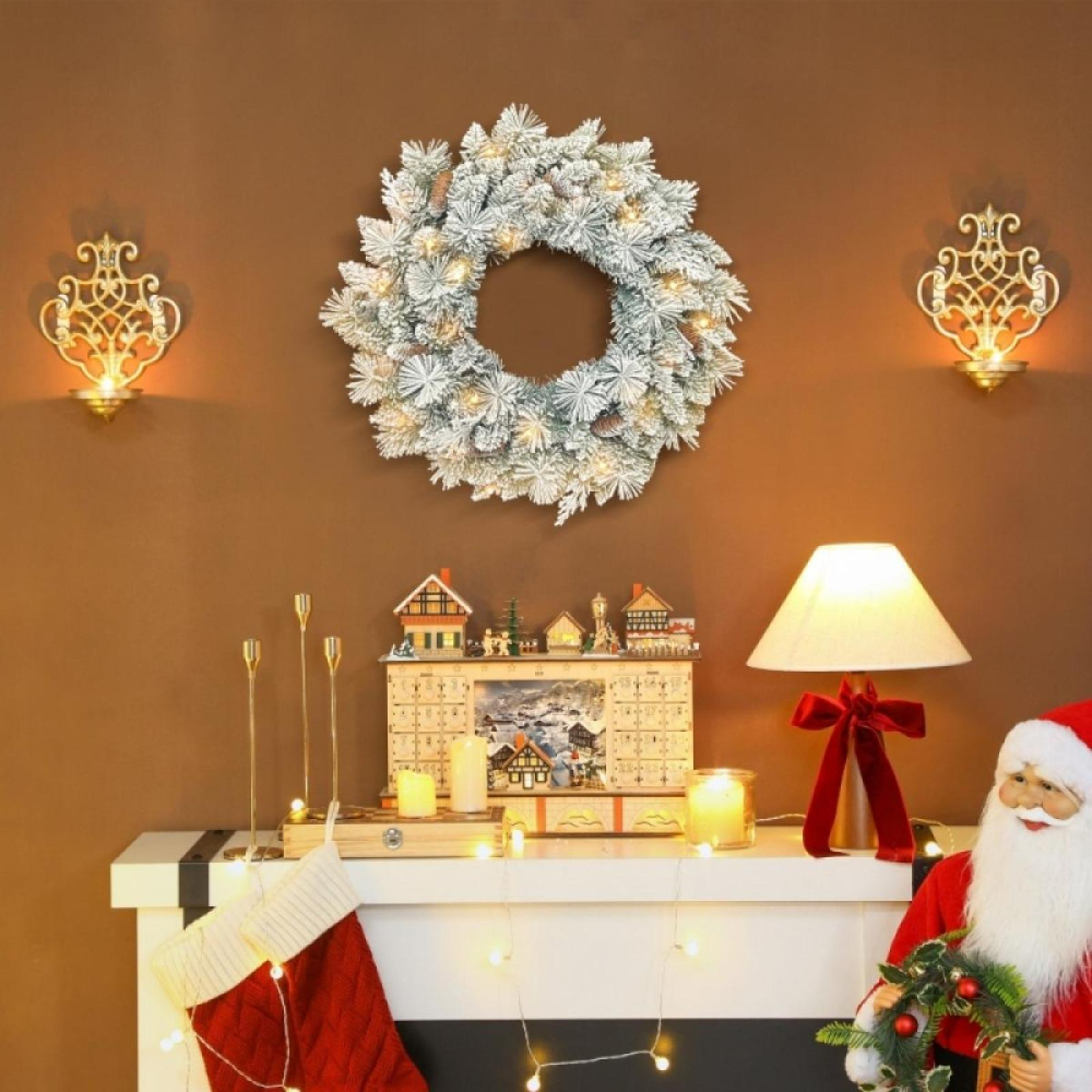 Festliche Szene. Ein Weihnachtskranz hängt über einem Kamin. Weihnachtsschmuck und Santa Claus sind zu sehen.