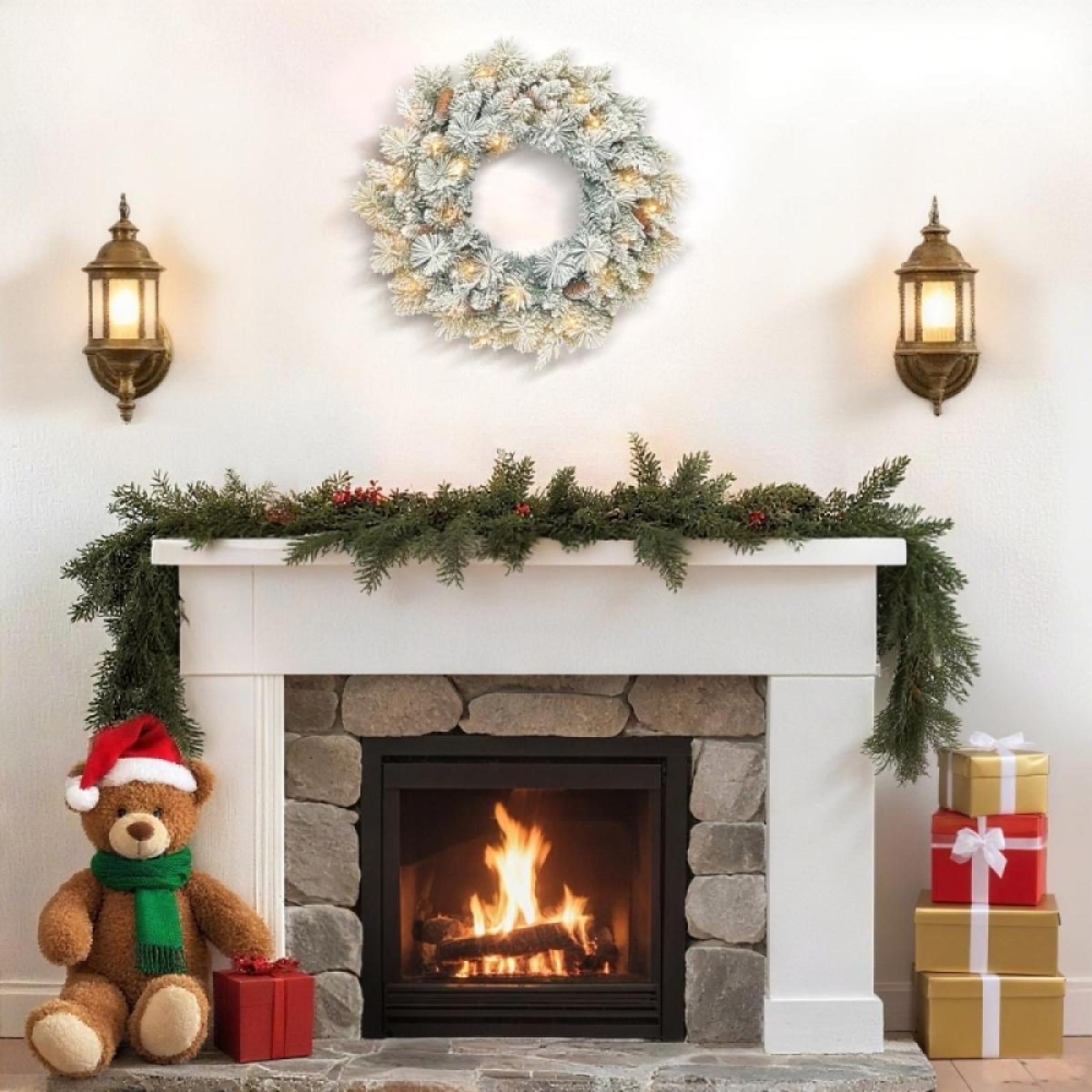 Ein Kamin, der zu Weihnachten mit einem Kranz, einer Girlande, einem Teddybären und Geschenken geschmückt ist. Feuer im Kamin.