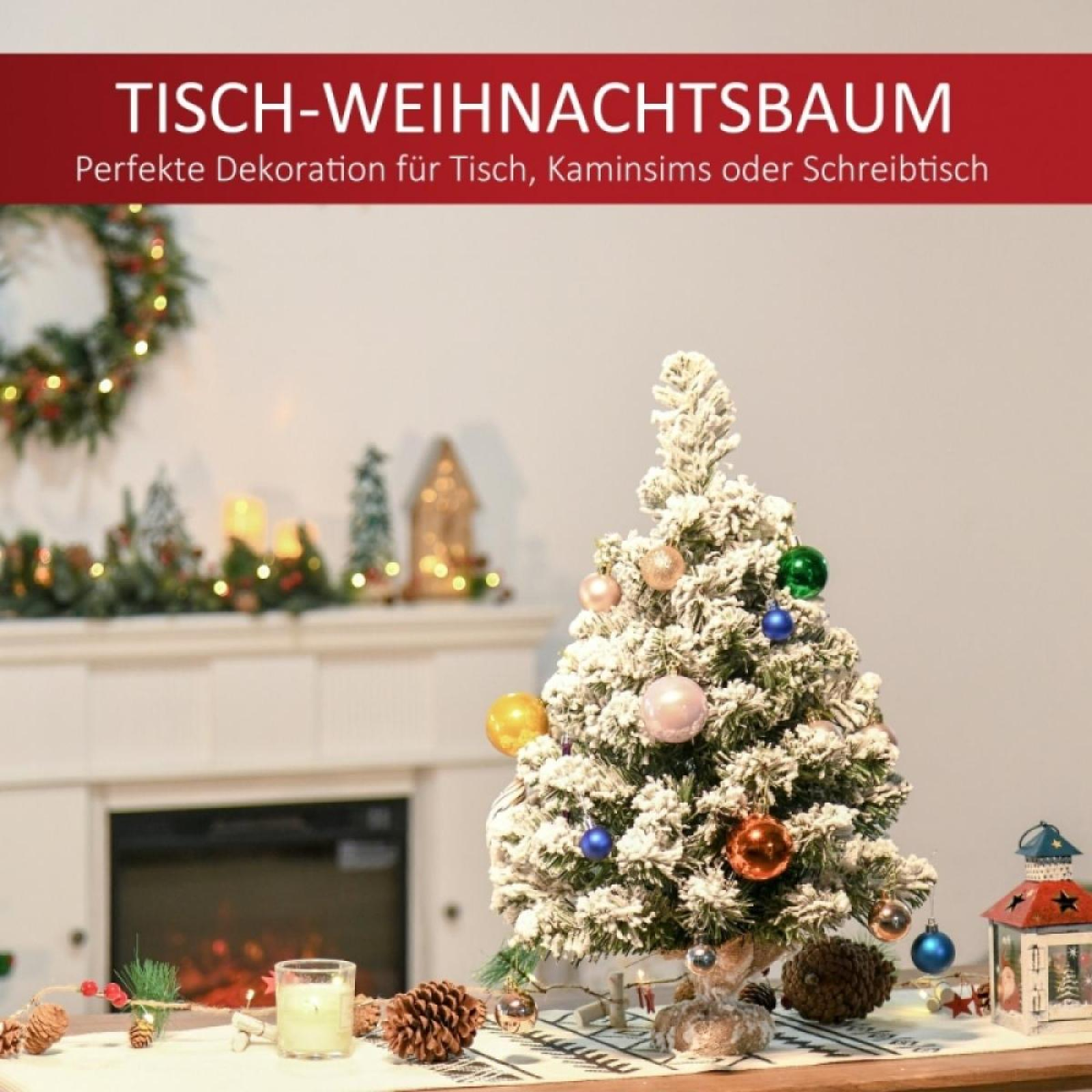 Ein kleiner, schneebedeckter Weihnachtsbaum mit Ornamenten. Ein Kamin und Dekorationen sind im Hintergrund. Eine Kerze steht davor.
